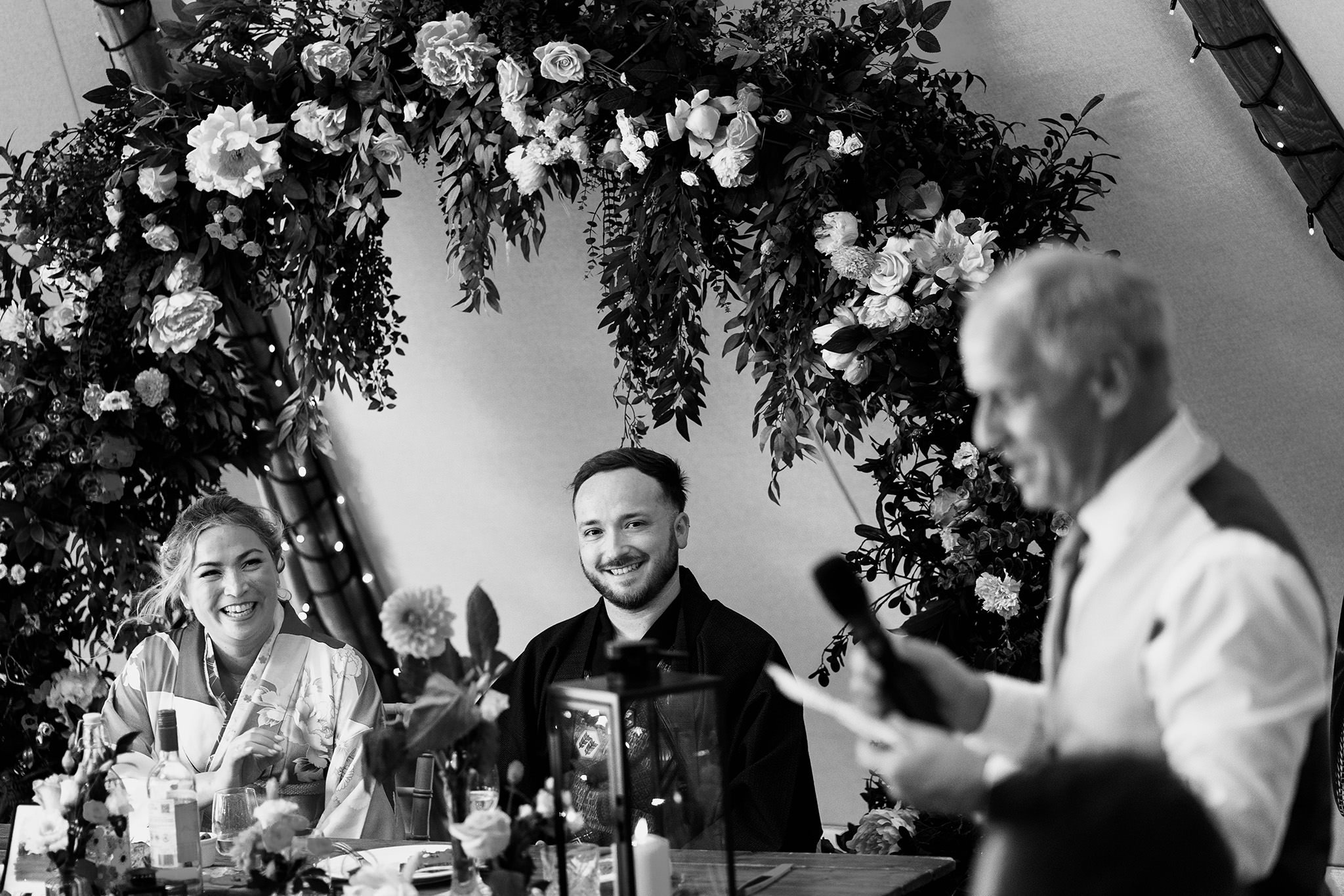 bride and groom listen to wedding speech at tipis at riley green