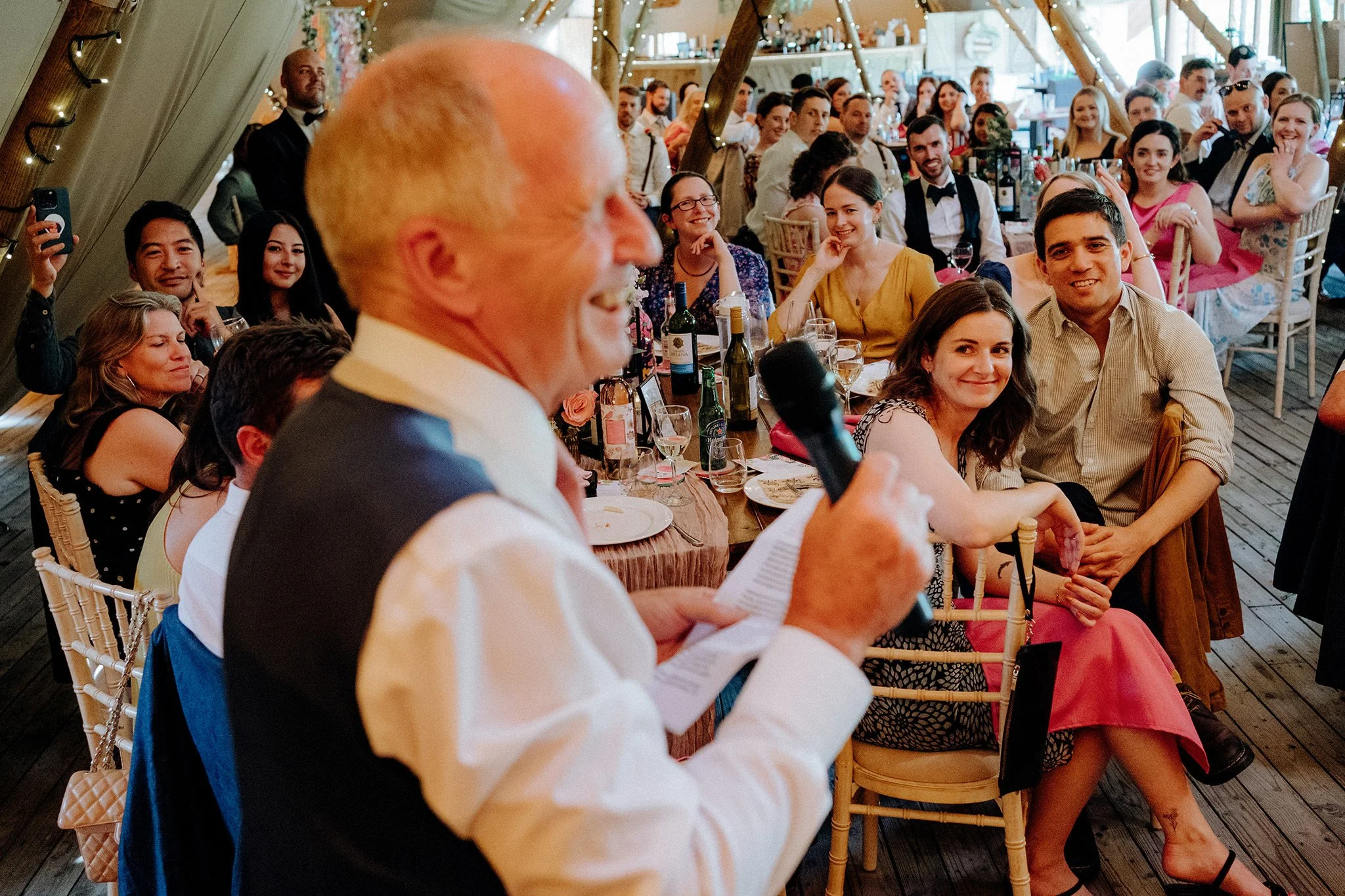 guests listen to father of the bride speech at tipis at riley green