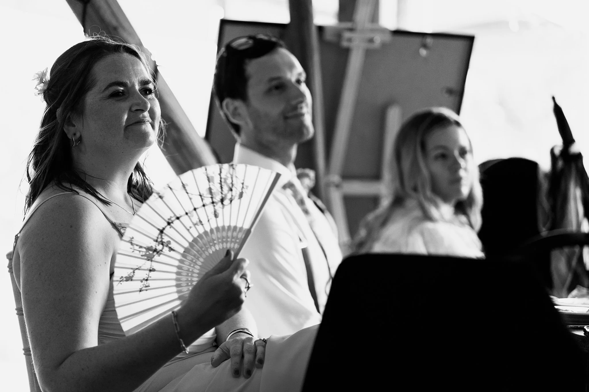 guest waves a fan during speeches at tipis at riley green