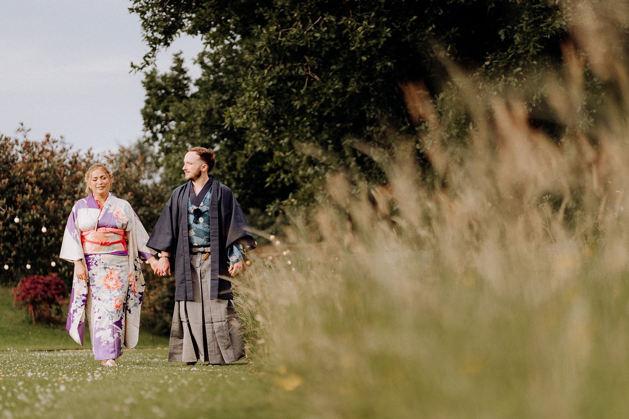 bride and groom go for a walk in their kimonos at tipis at riley green
