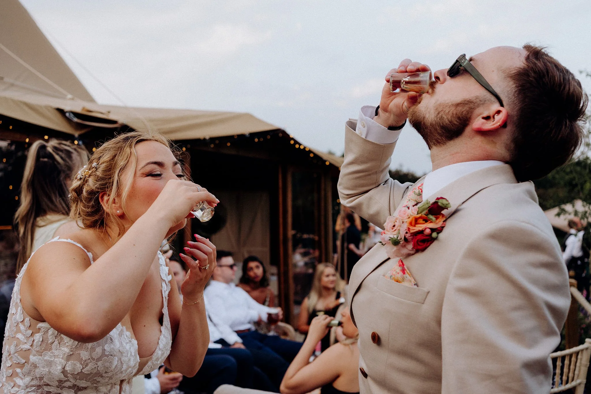 bride and groom doing shots at tipis at riley green