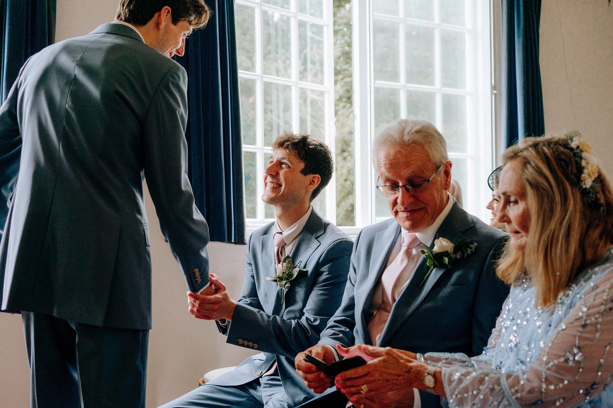 groom shaking hands with brother village hall wedding