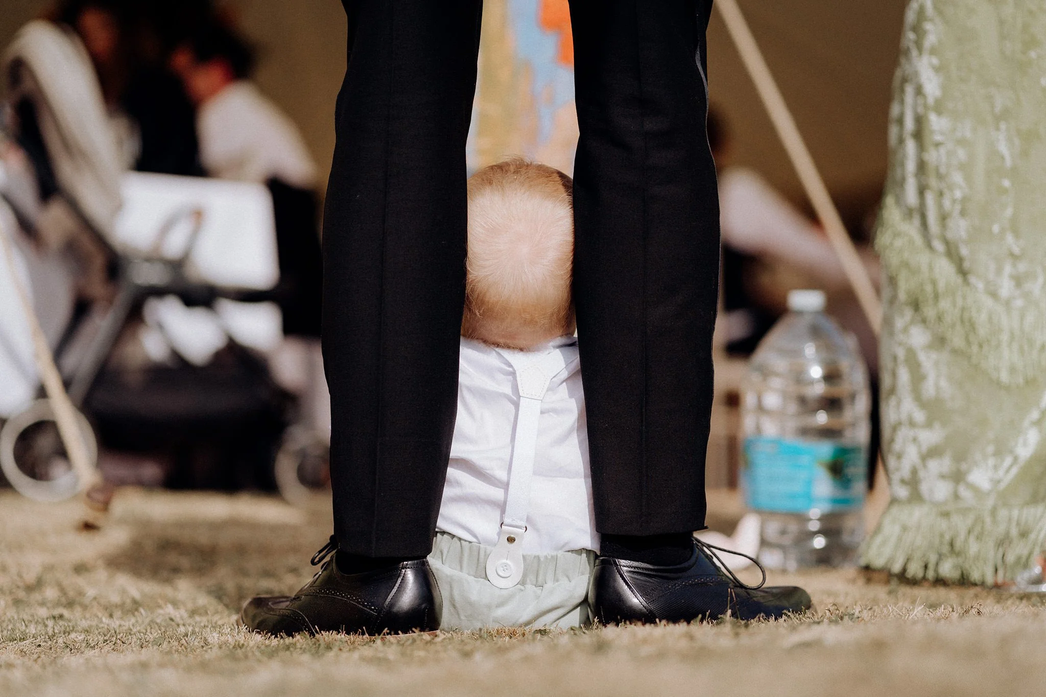 baby sits with dad at marquee wedding