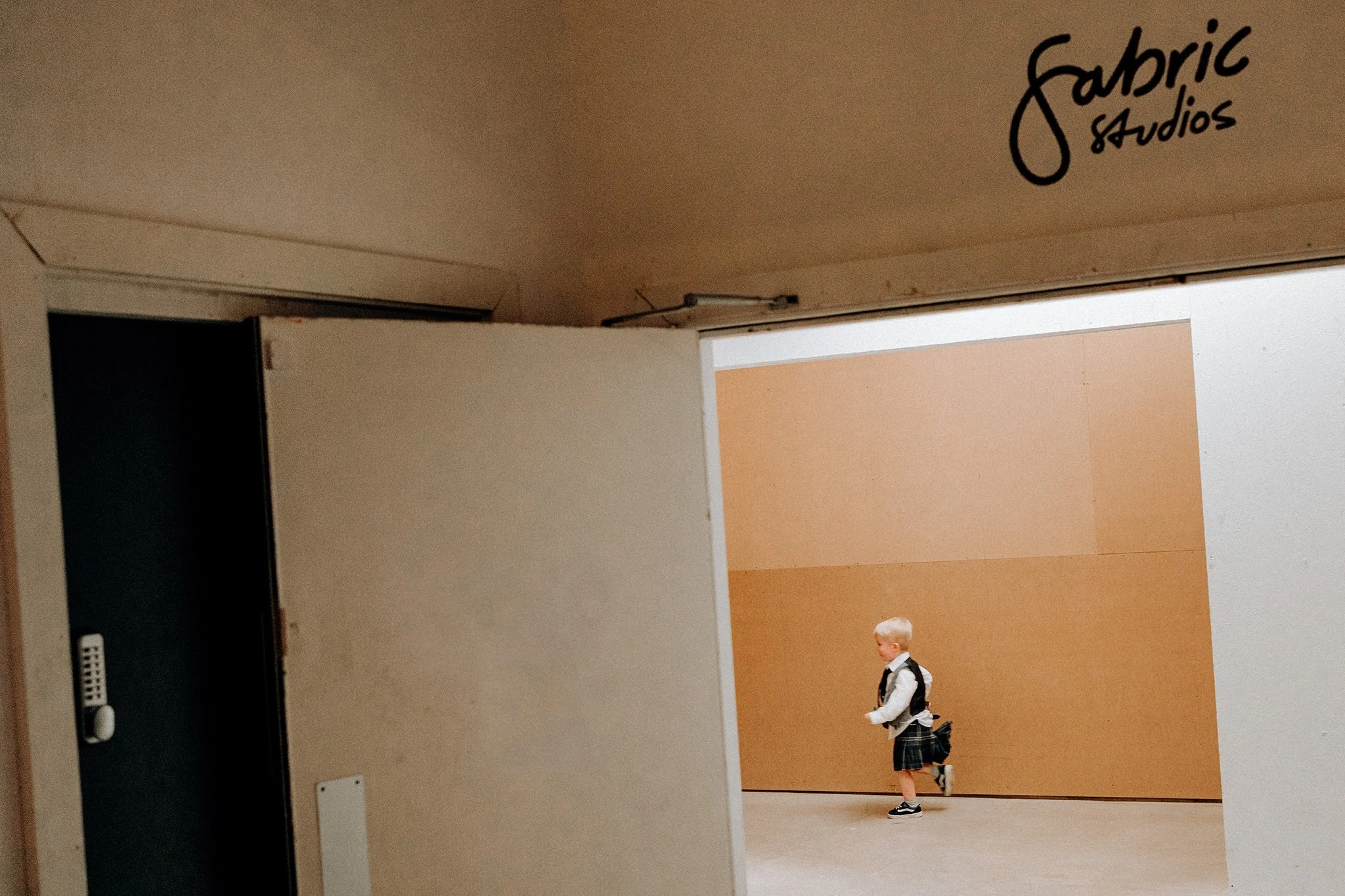 young wedding guest running around in a kilt at fabric studios liverpool