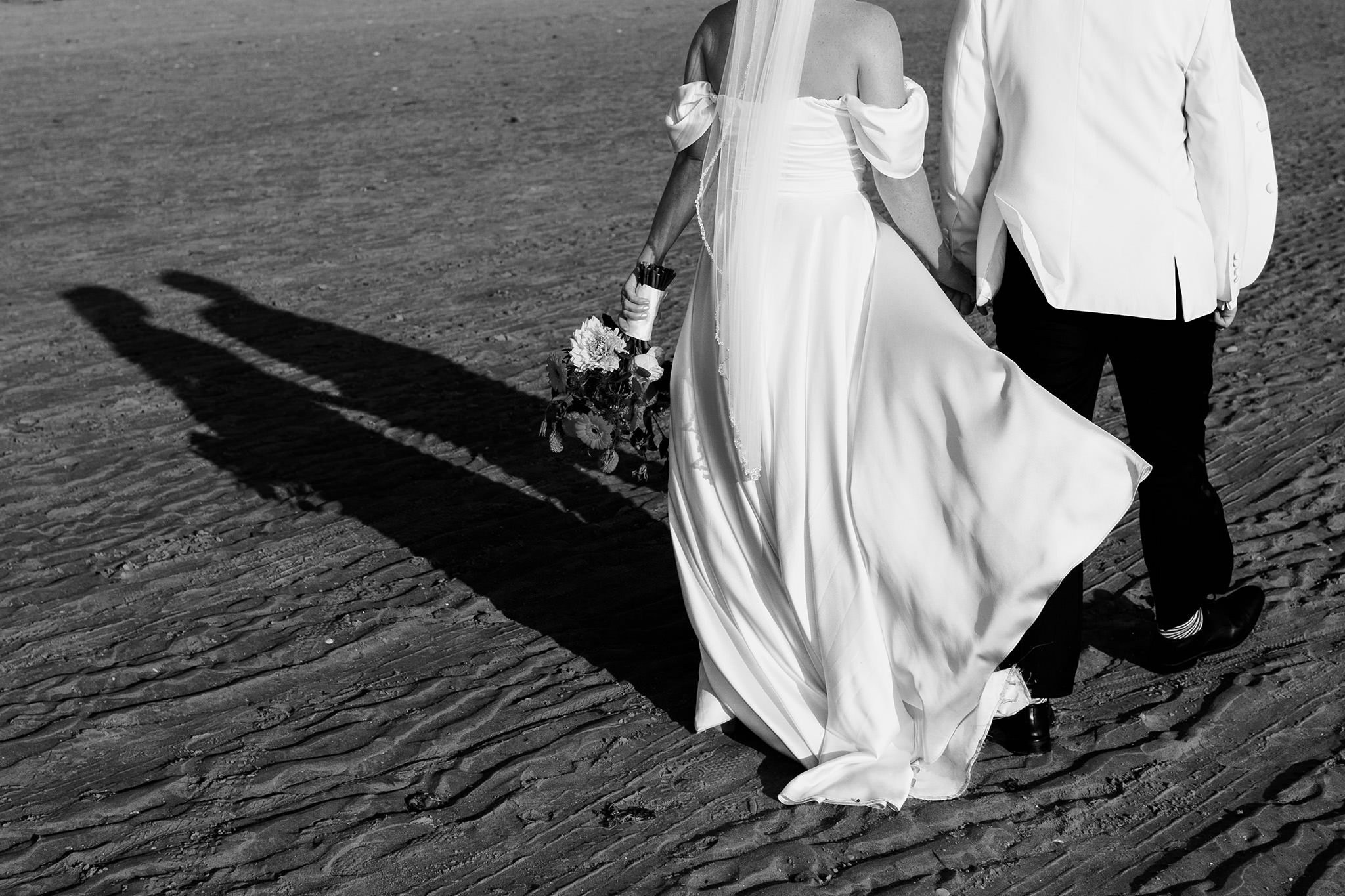 bride and groom taking a beach walk