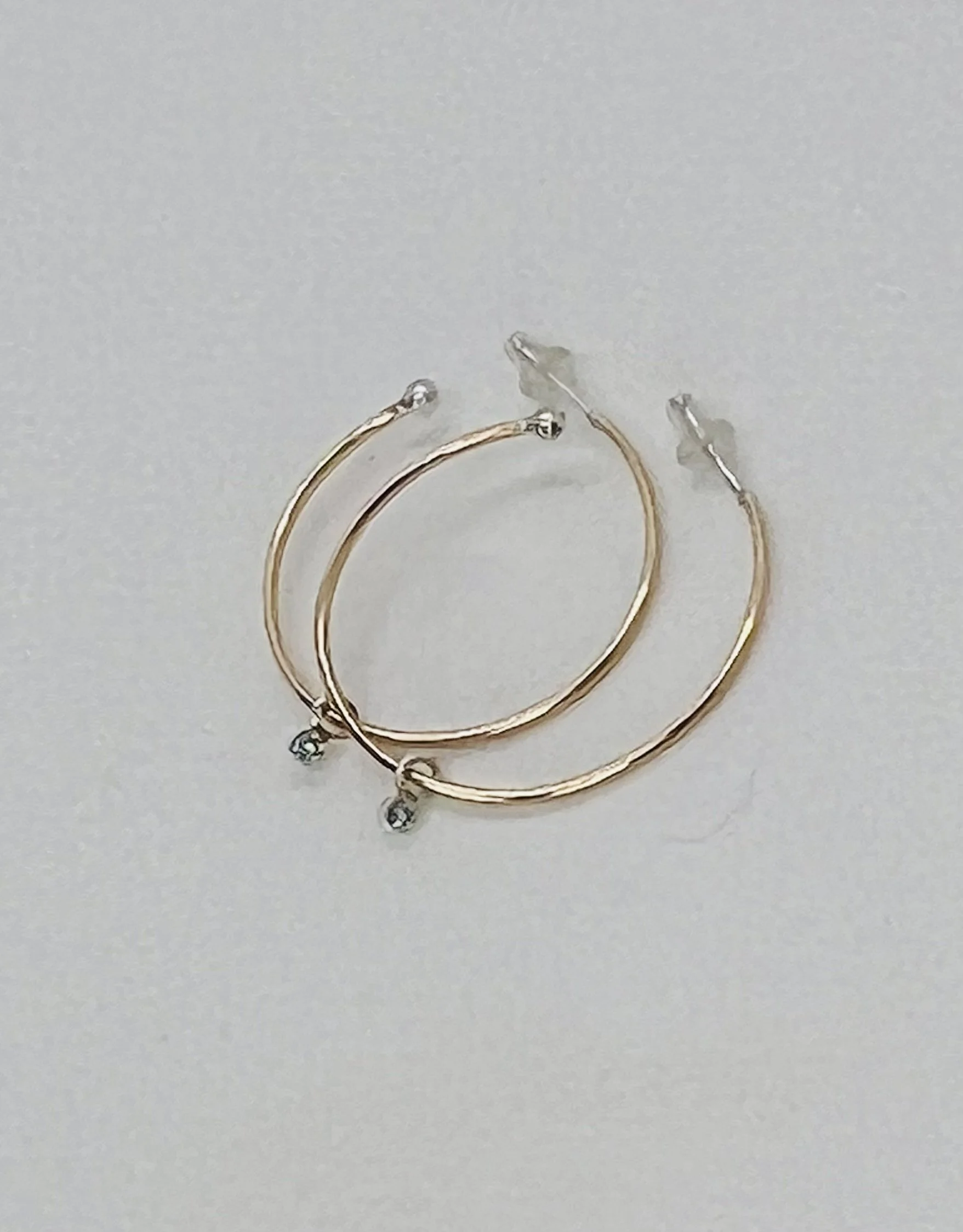 Gold filled hoops with bezel set blue zircon charm.