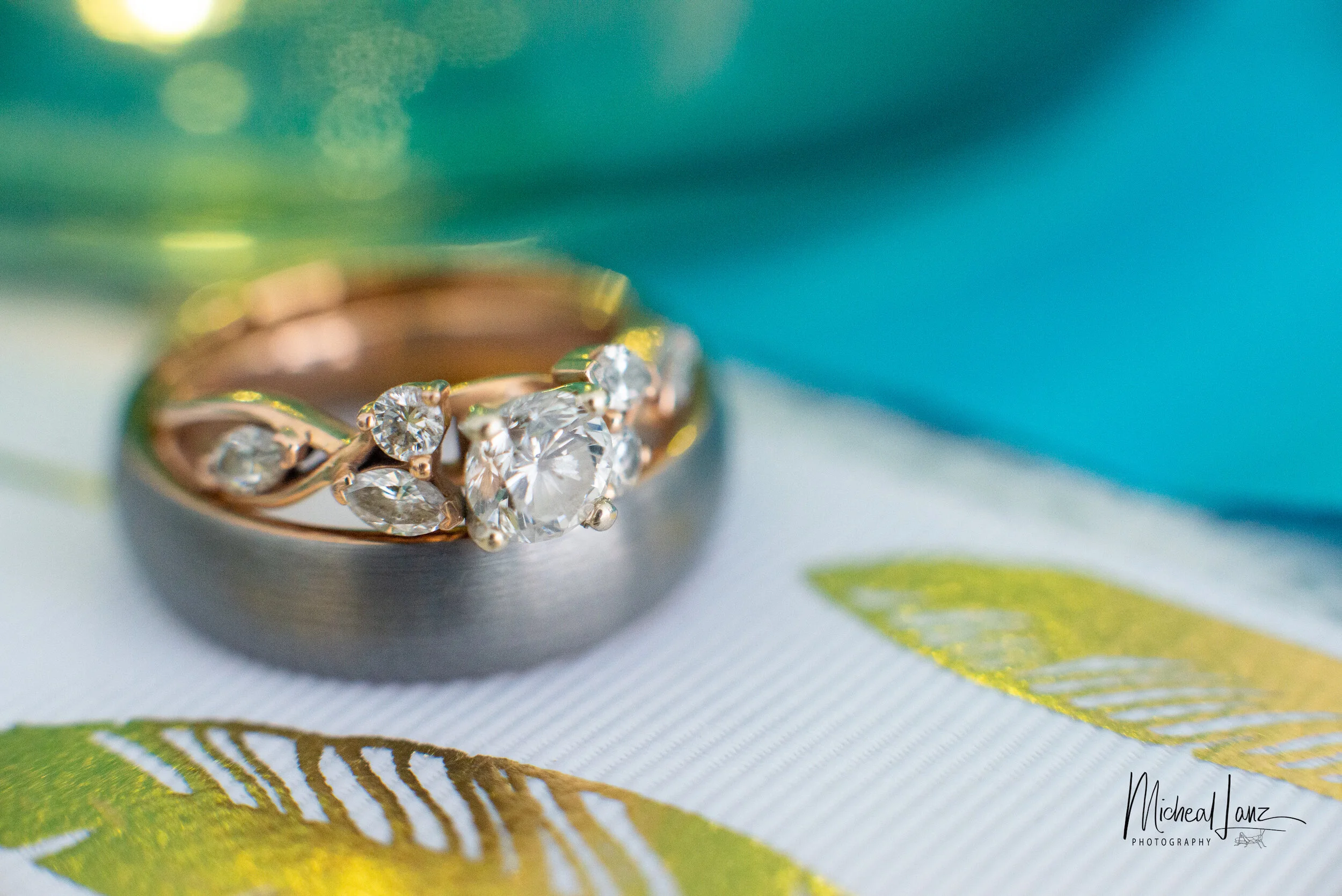Close-up of a gold ring with multiple diamonds on a colorful, patterned surface.