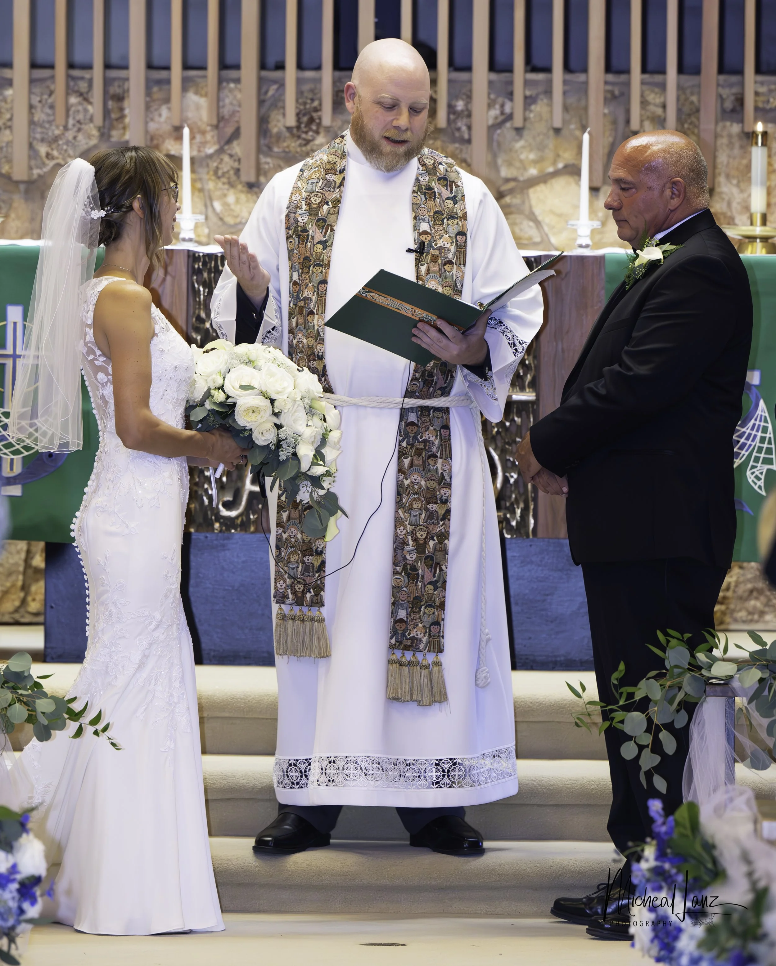A couple getting married during a religious wedding ceremony in a church, with a priest officiating.