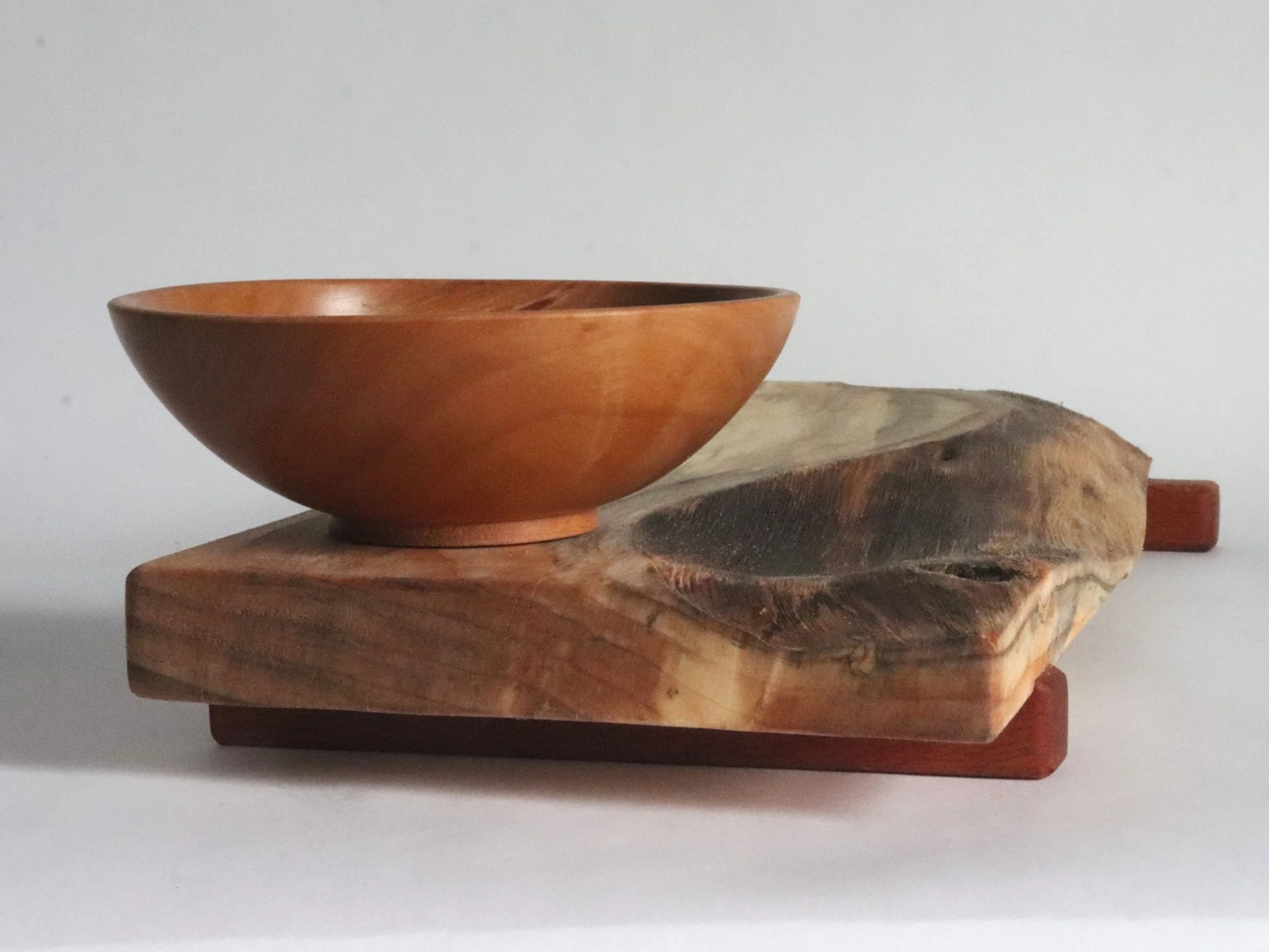 Mid-angle view of wood serving tray and bowl set displaying 1.5-inch height, sapele mahogany rail feet, and overall proportions