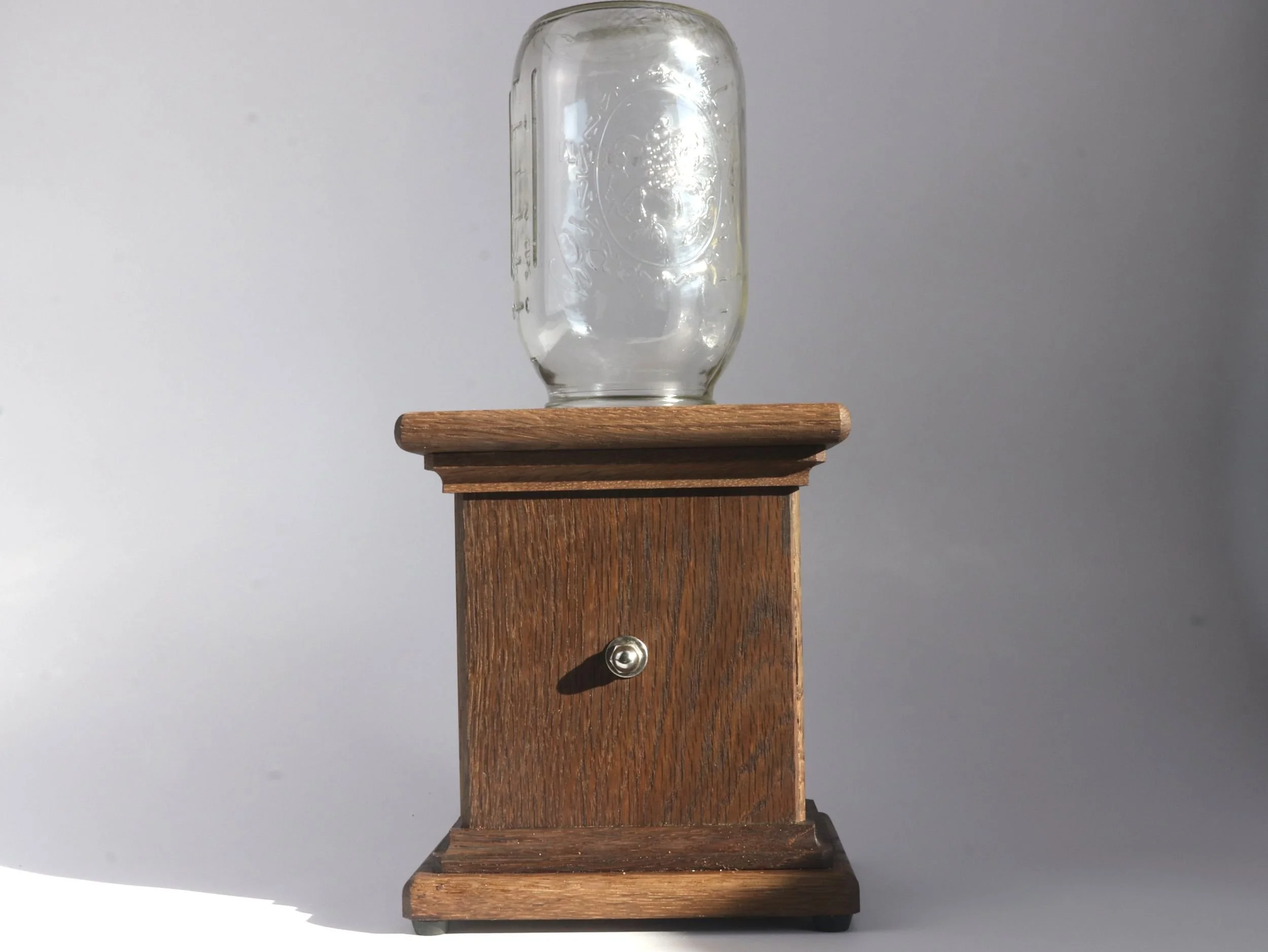 Rear view of fumed white oak candy dispenser displaying craftsmanship and turning mechanism detail