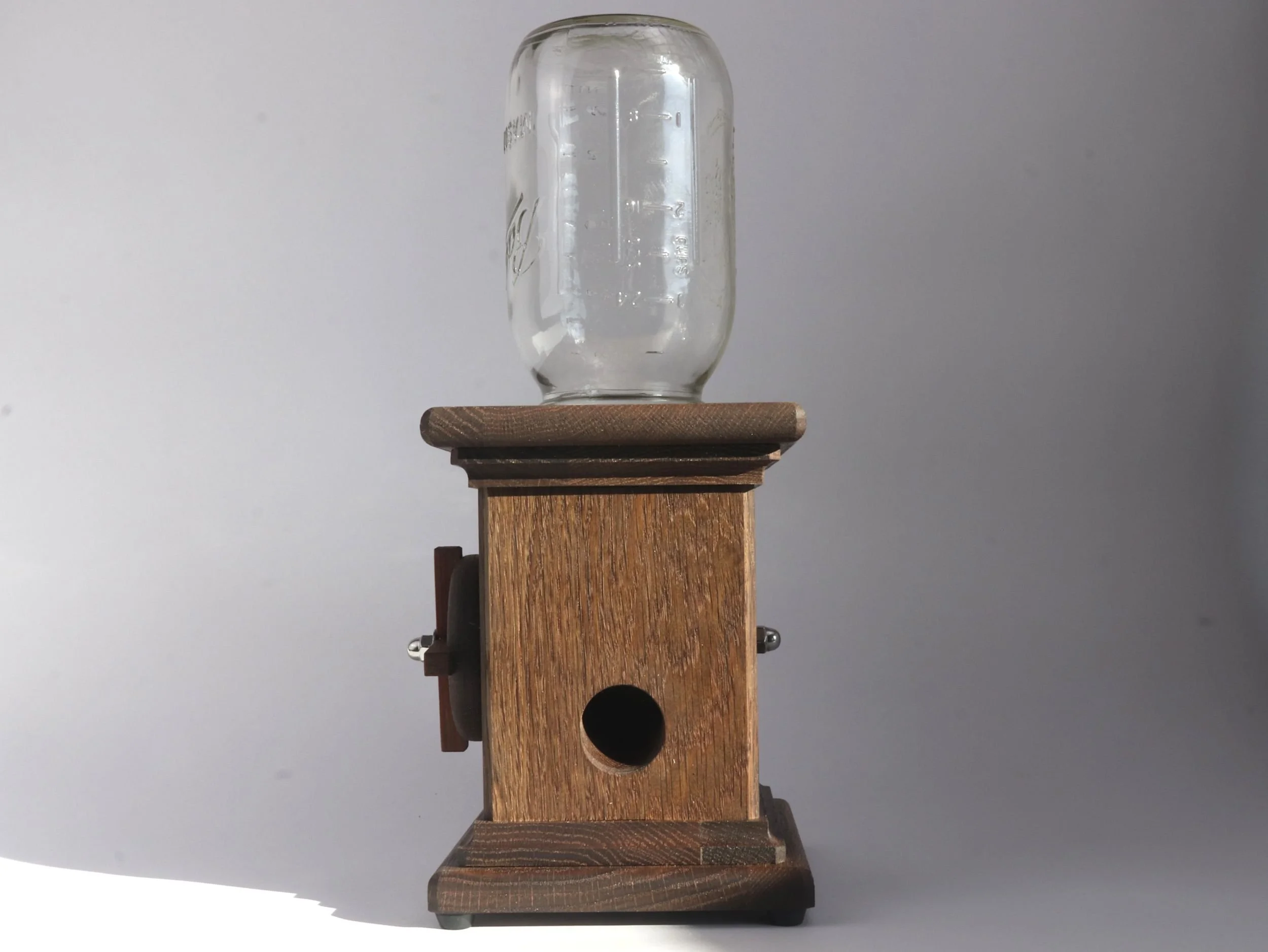 Left side profile of handcrafted candy dispenser showing rubber feet and base construction detail