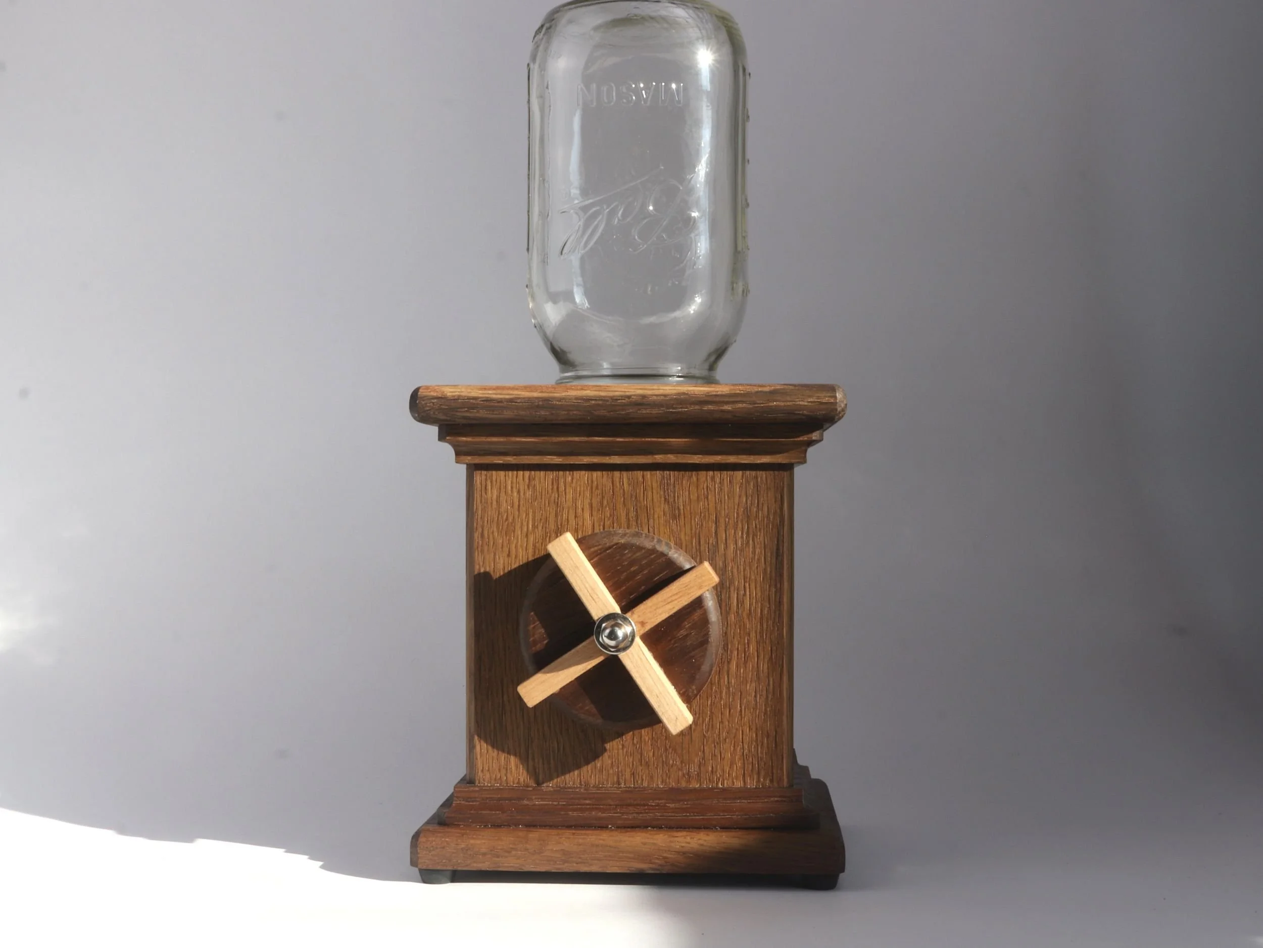 Fumed white oak candy dispenser with light maple X detail showing empty glass jar and mechanism
