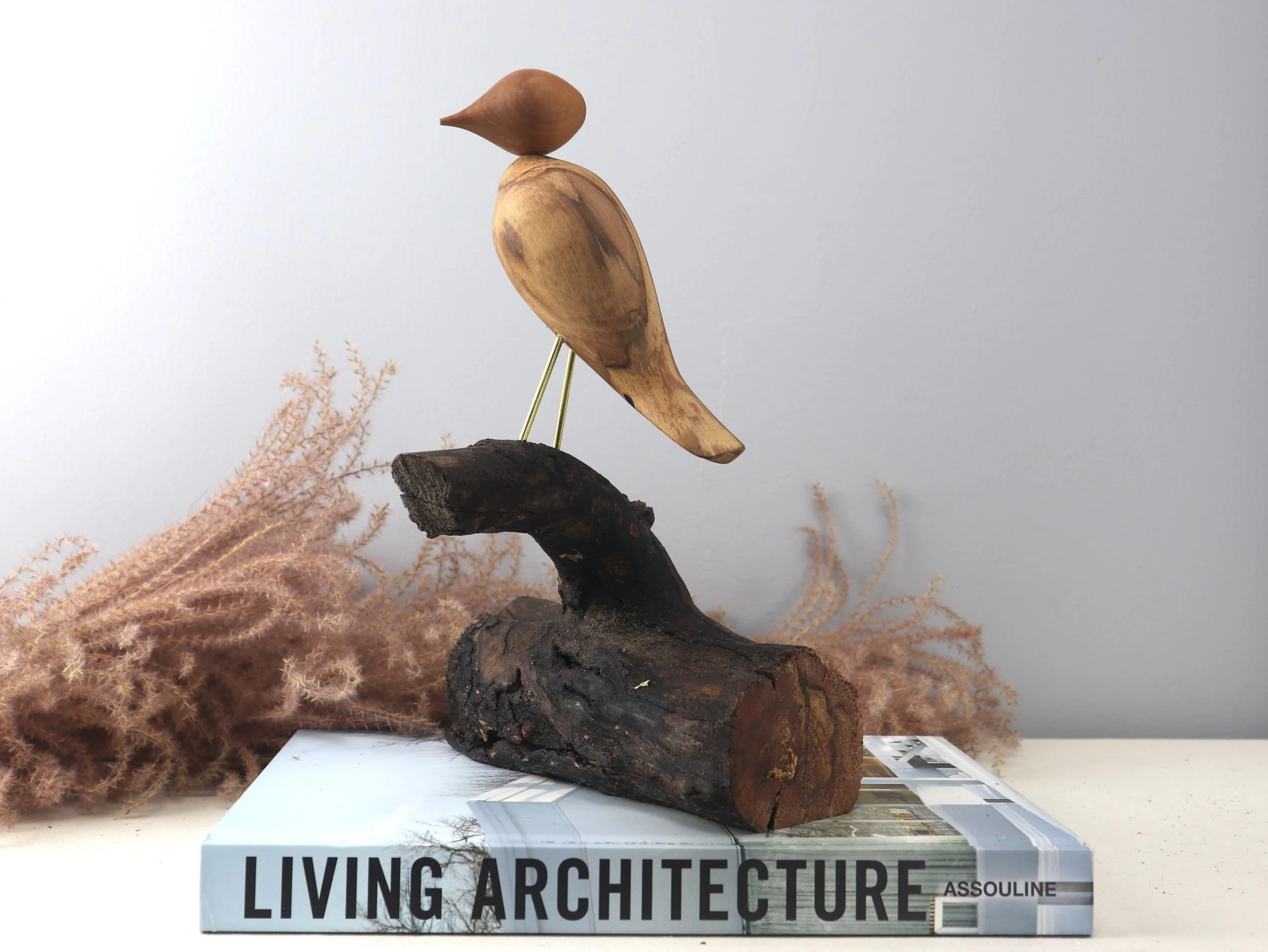 Handmade wooden bird art sculpture rear view displaying natural dogwood grain patterns and brass leg details