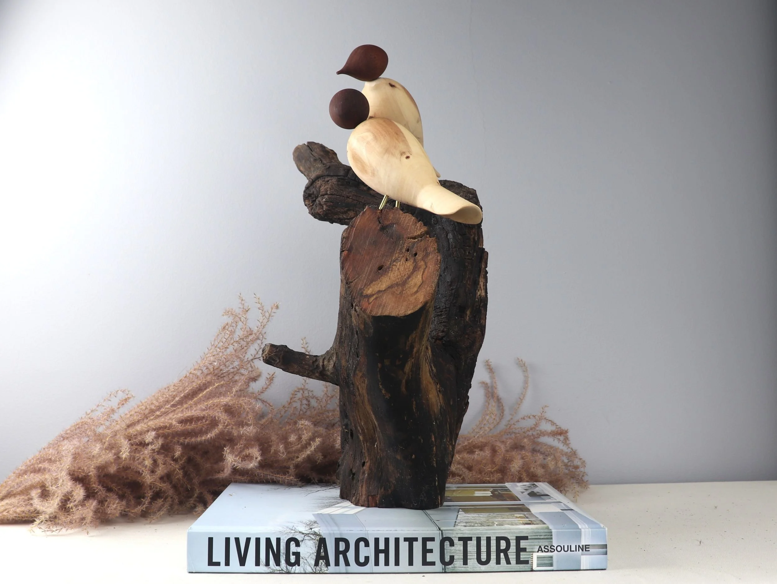Interactive bird sculpture showing side profile of dogwood carved birds with turning mahogany heads on Y-shaped branch