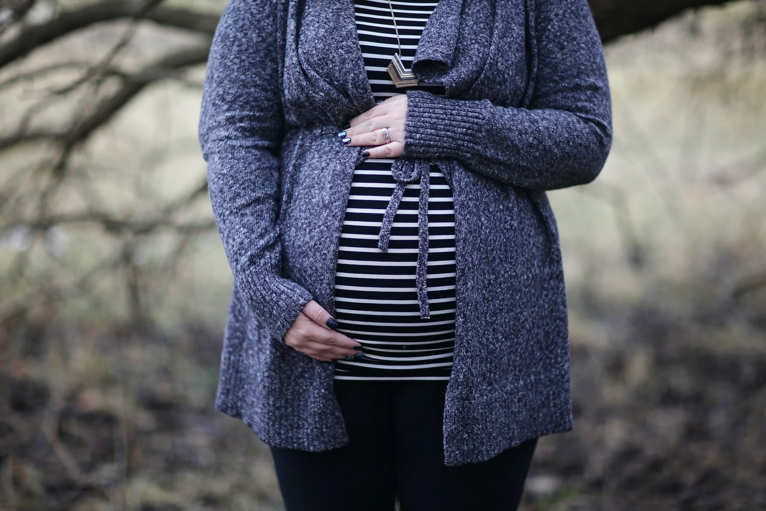 woman pregnant in black and white striped shirt standing