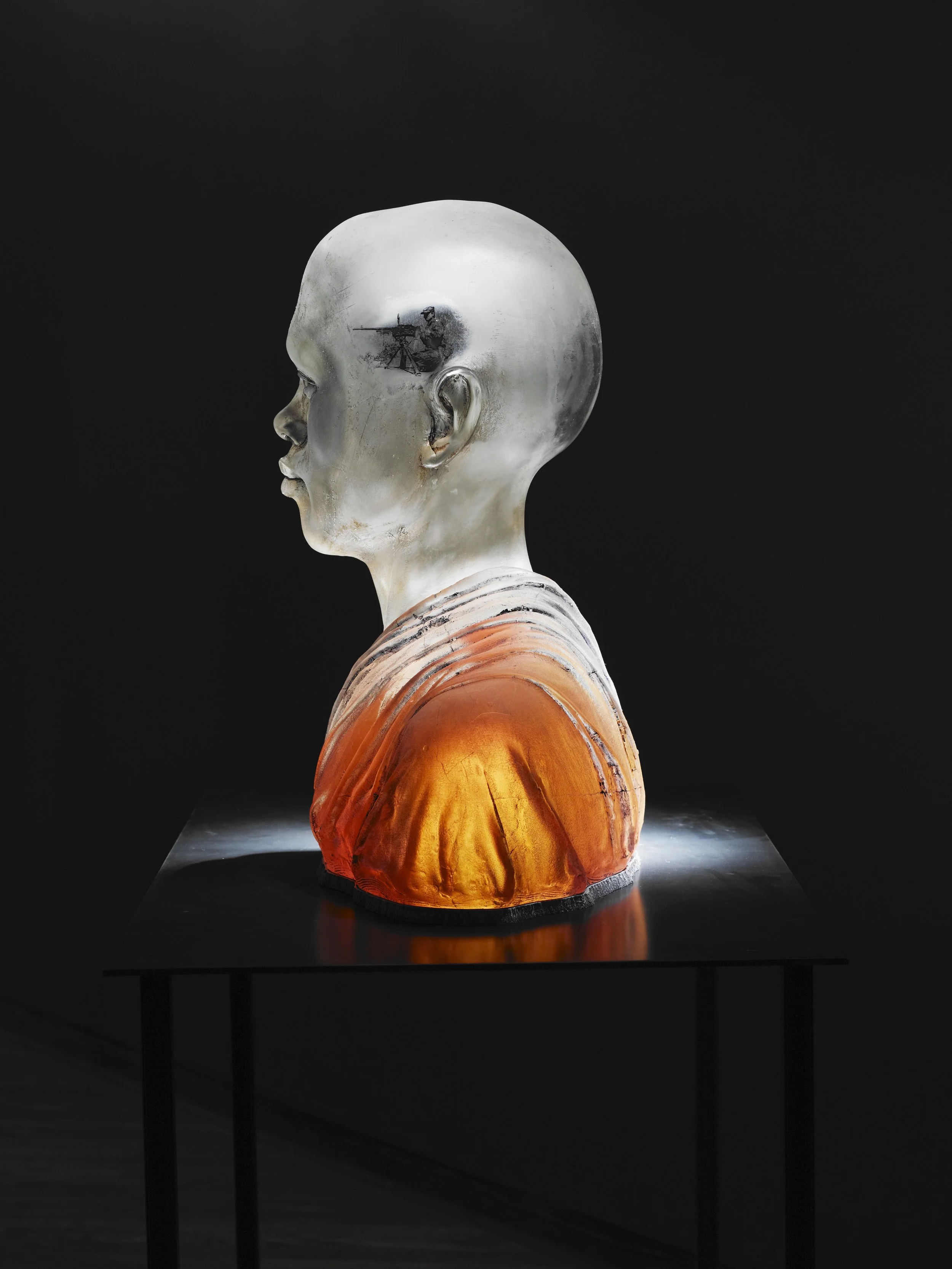 Projections in Tun Yee | Mold Blown Glass, Concrete, Mixed Media | 25.5" H x 24.5" W x 13" D | 2010
Blown glass figure, concrete robe, internal projector plays video taken in conflict zones in Burma. These images play inside the visual cortex and ar