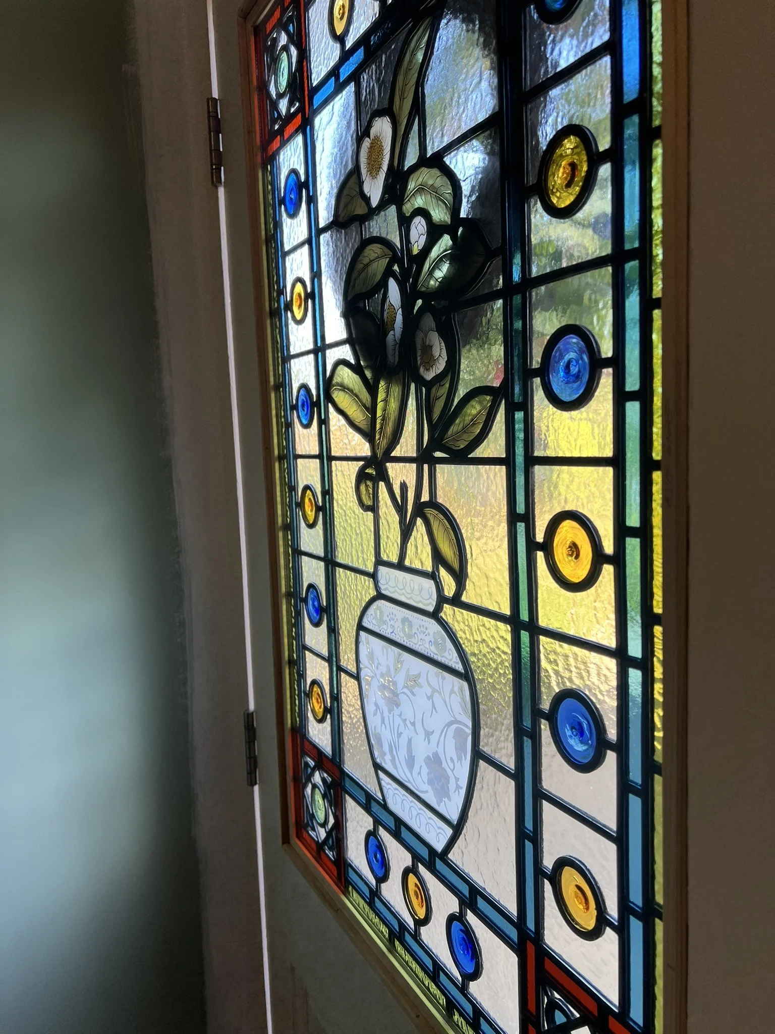 stained glass window in Victorian style, featuring an intricate vase design with flowers, leaves and mouth-blown roundels and hand painted, kiln fired house name