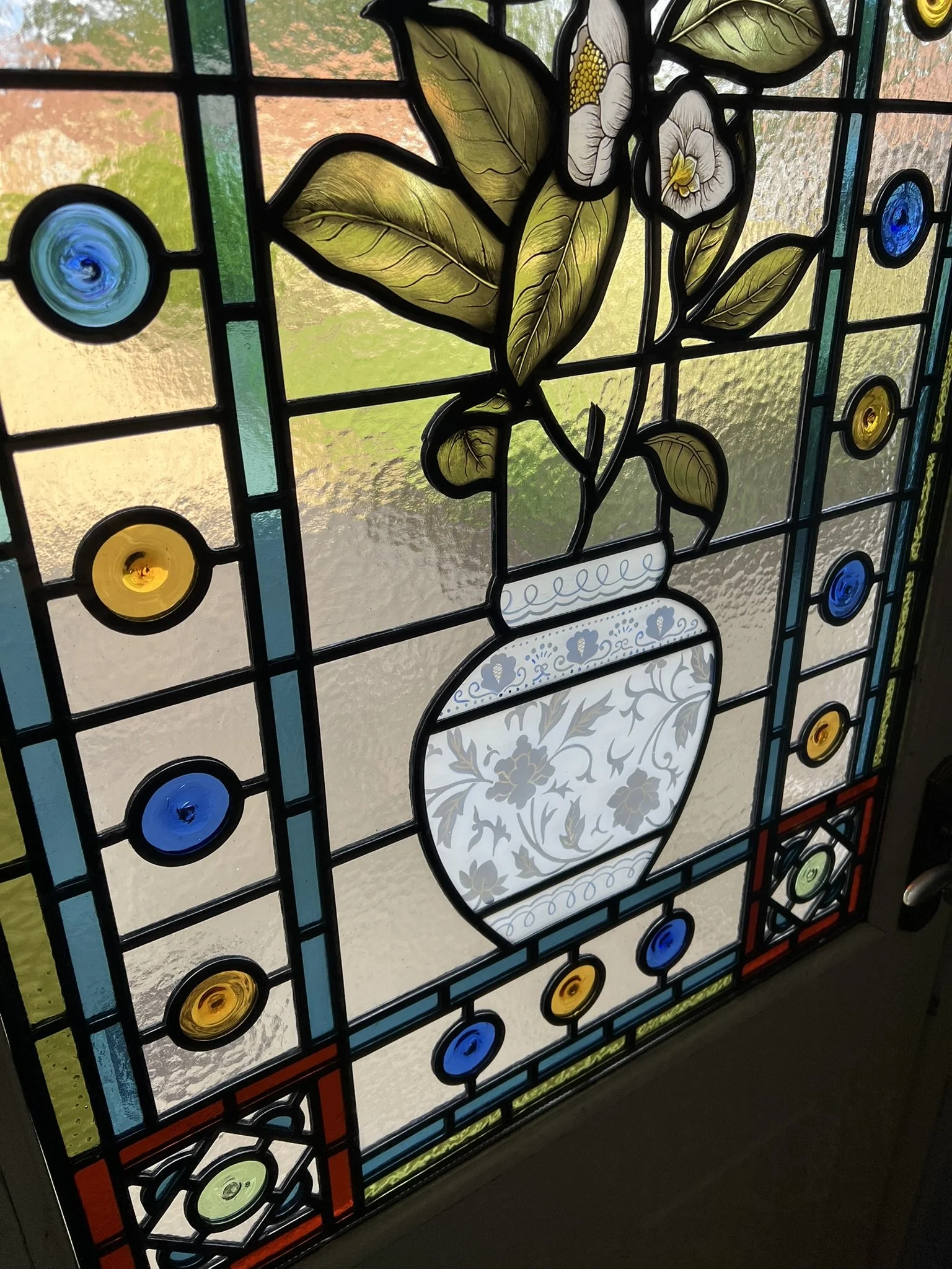 stained glass window in Victorian style, featuring an intricate vase design with flowers, leaves and mouth-blown roundels and hand painted, kiln fired house name
