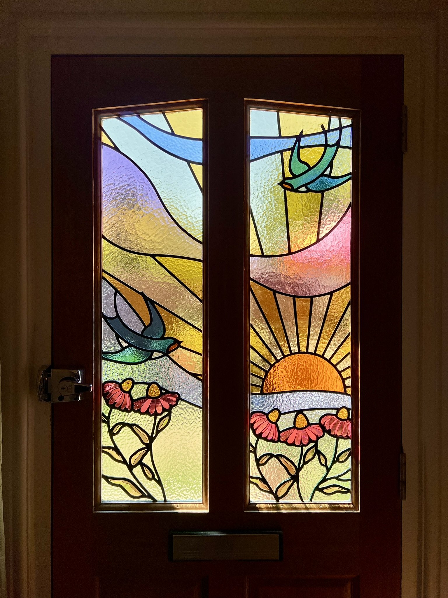 maximalist stained glass front door set featuring swallows, a sunset and fuchsia pink cone flowers