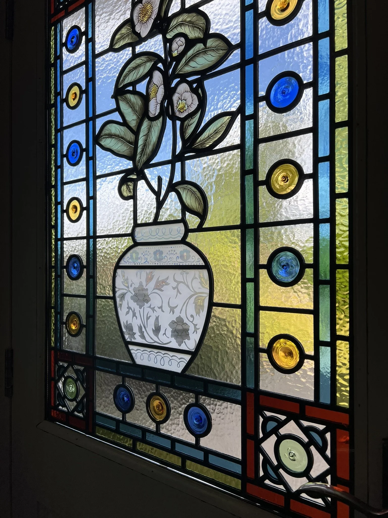 stained glass window in Victorian style, featuring an intricate vase design with flowers, leaves and mouth-blown roundels and hand painted, kiln fired house name