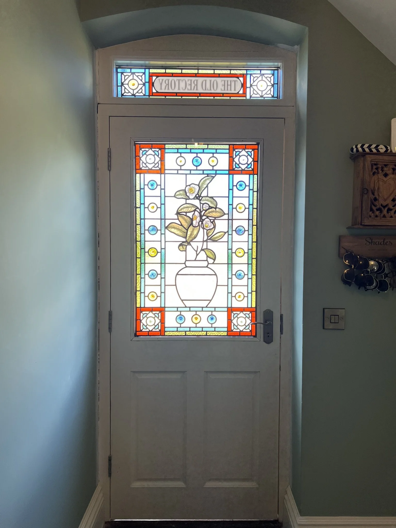 stained glass window in Victorian style, featuring an intricate vase design with flowers, leaves and mouth-blown roundels and hand painted, kiln fired house name