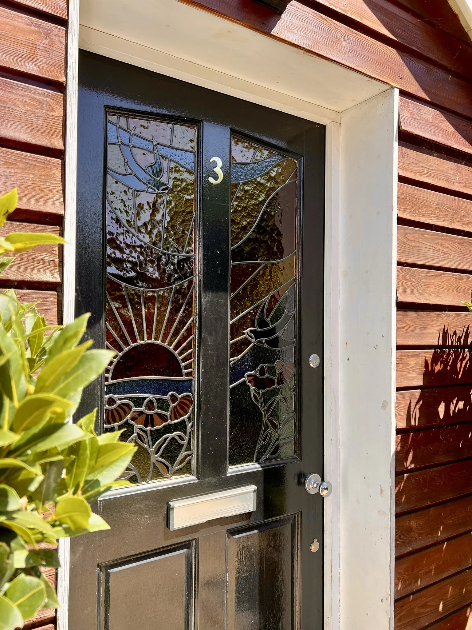 maximalist stained glass front door set featuring swallows, a sunset and fuchsia pink cone flowers