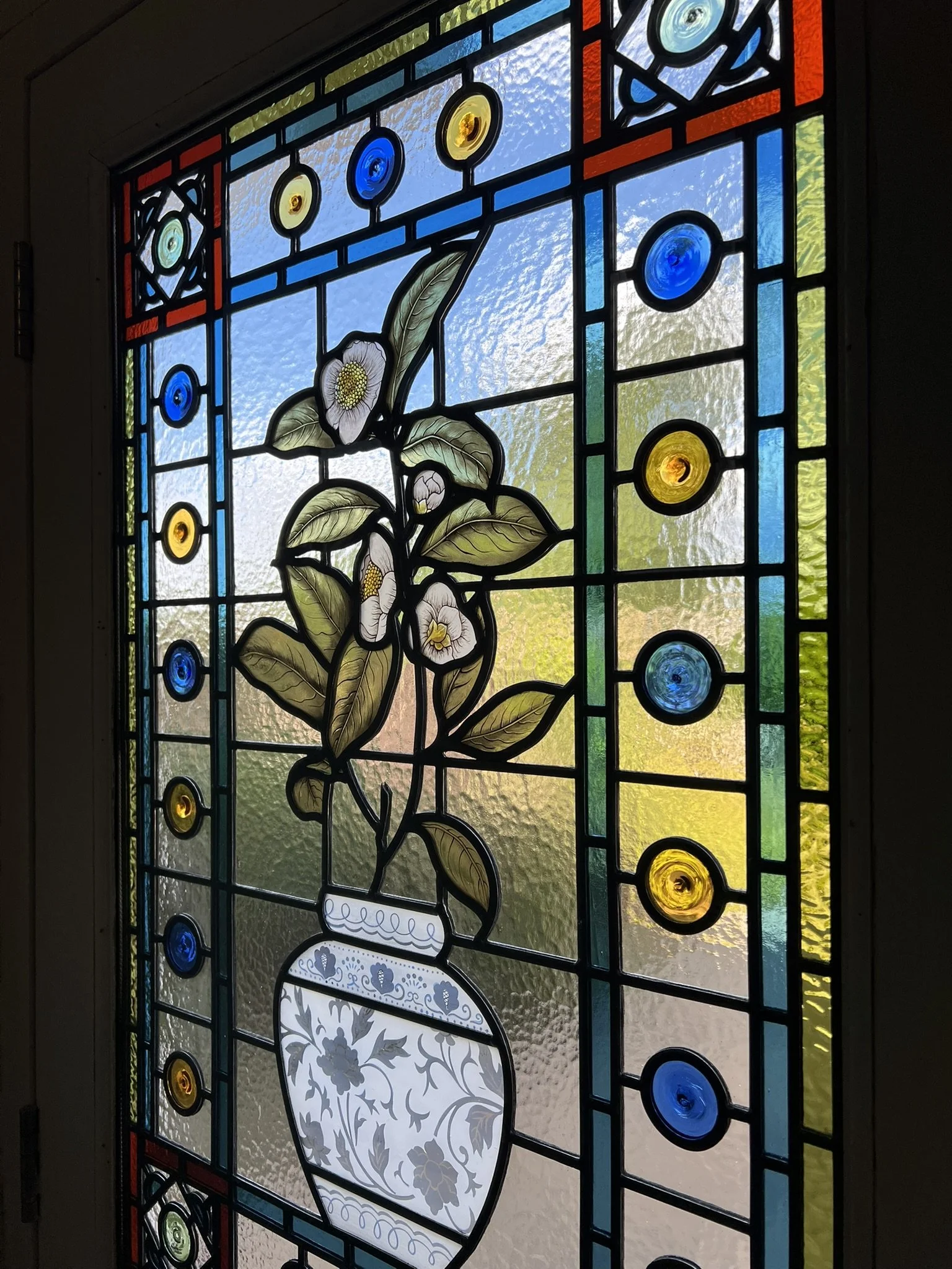 stained glass window in Victorian style, featuring an intricate vase design with flowers, leaves and mouth-blown roundels and hand painted, kiln fired house name
