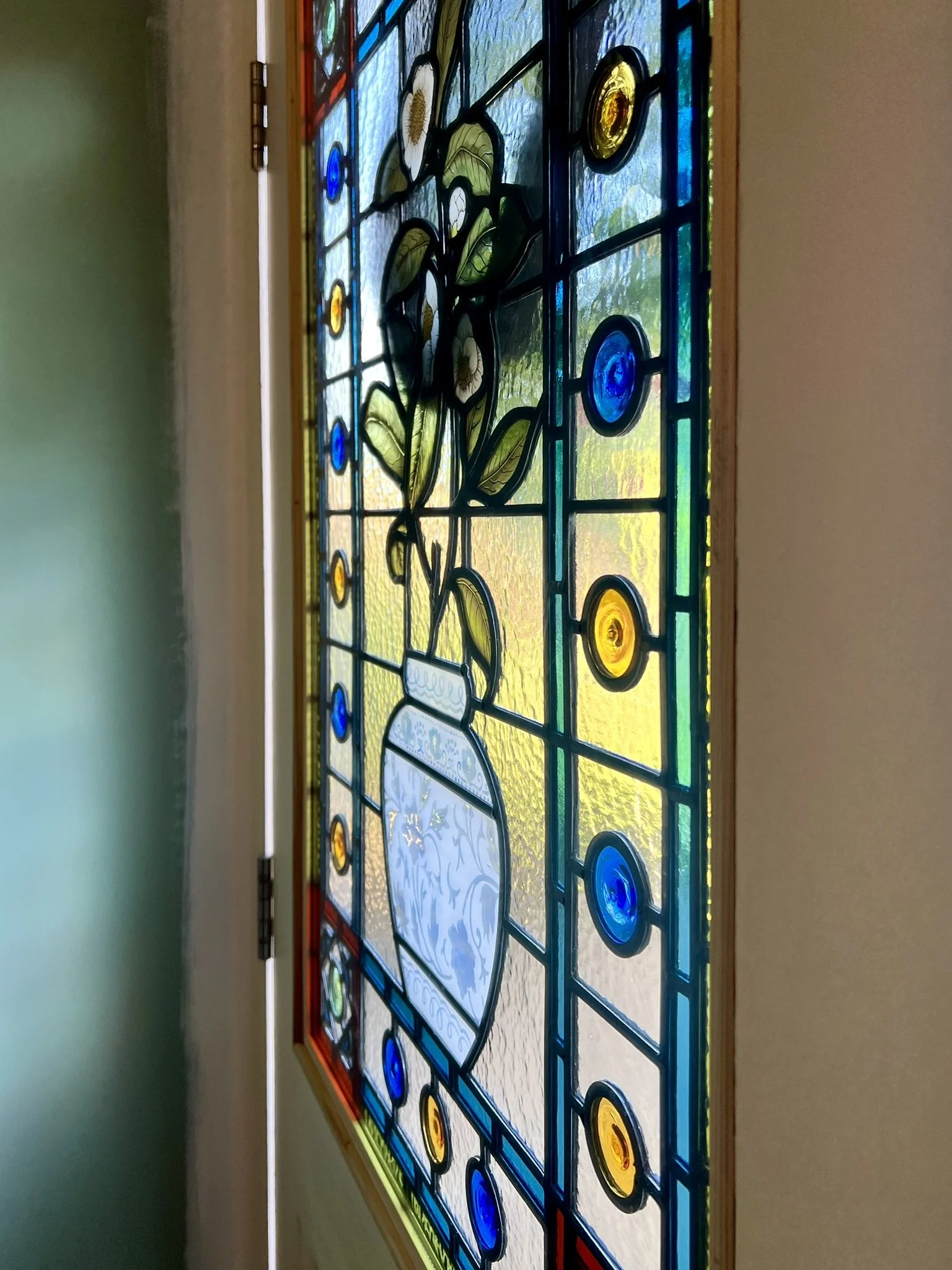 stained glass window in Victorian style, featuring an intricate vase design with flowers, leaves and mouth-blown roundels and hand painted, kiln fired house name