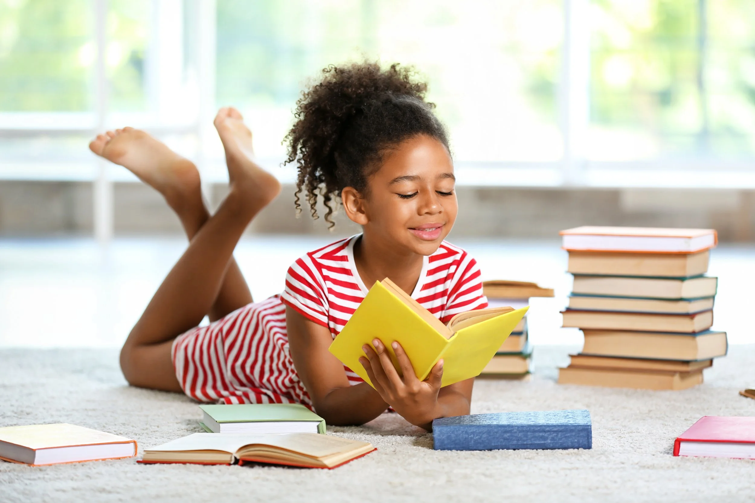 girl reading surrounded by books
