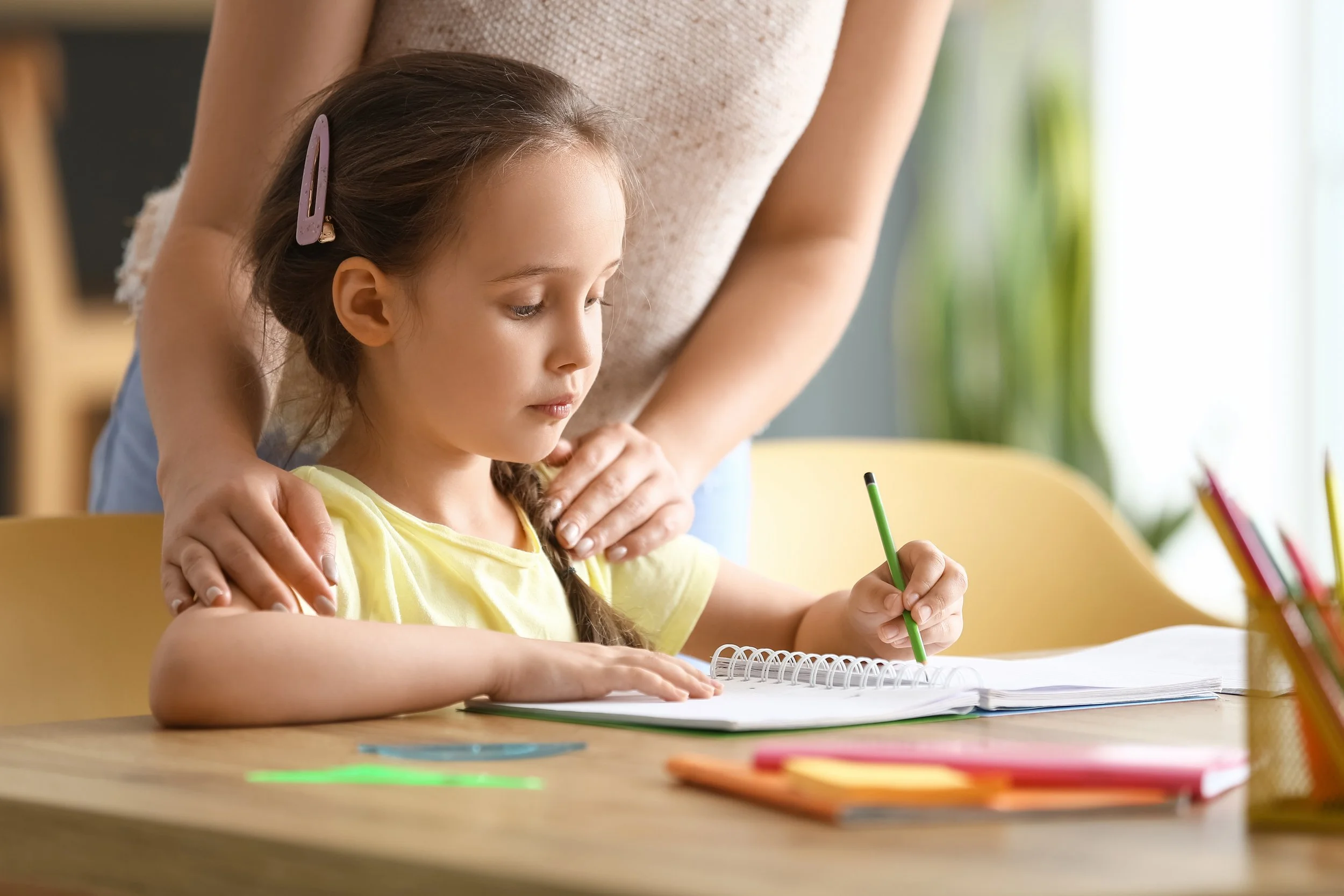 parent supporting girl with homework