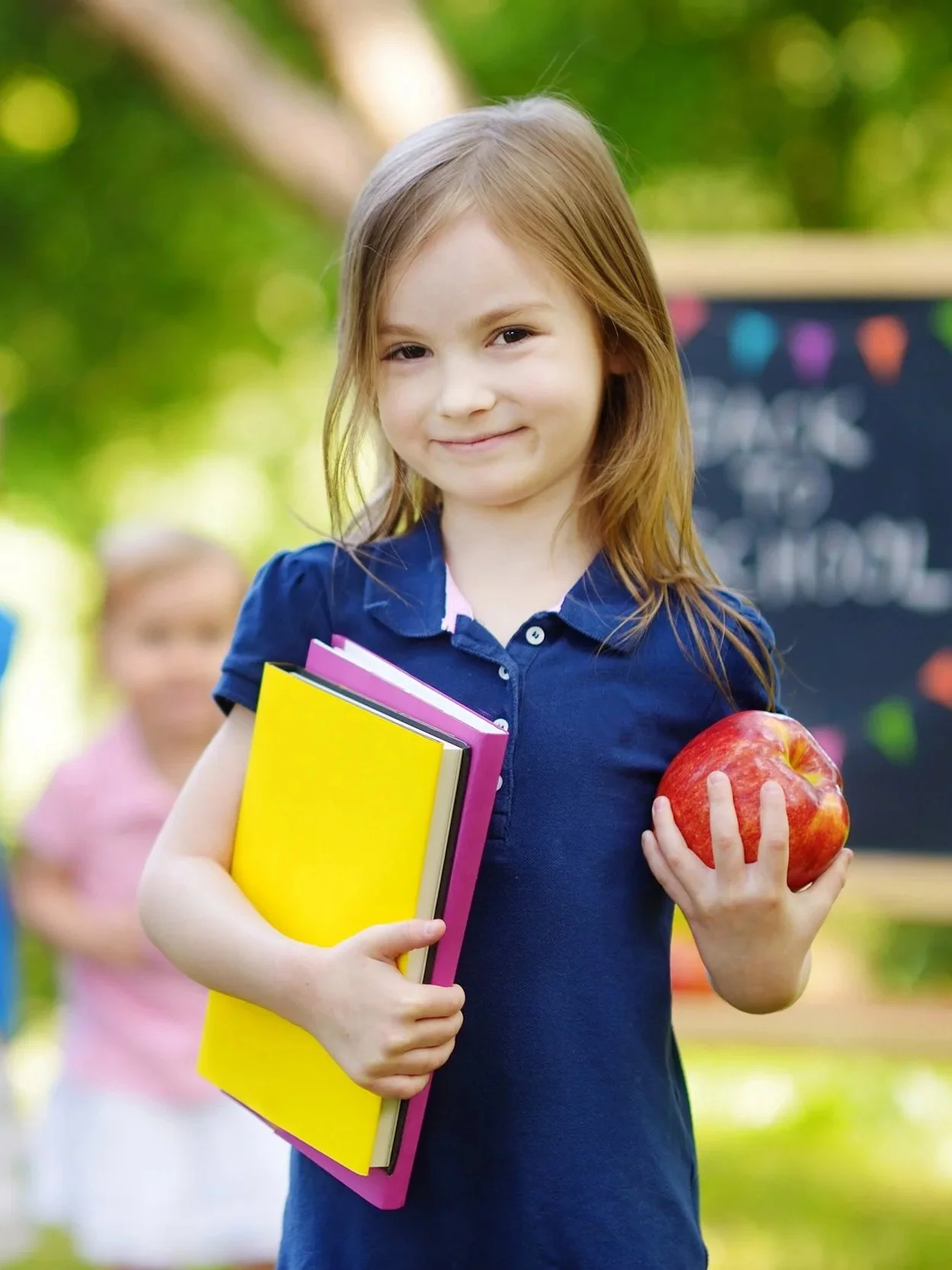confident young girl holding school books