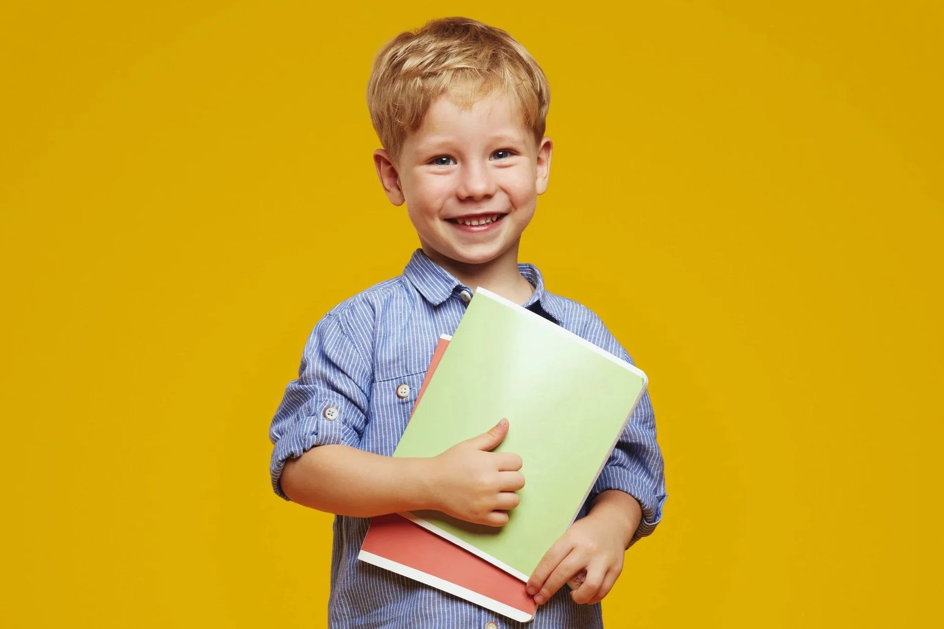 smiling boy holding school books