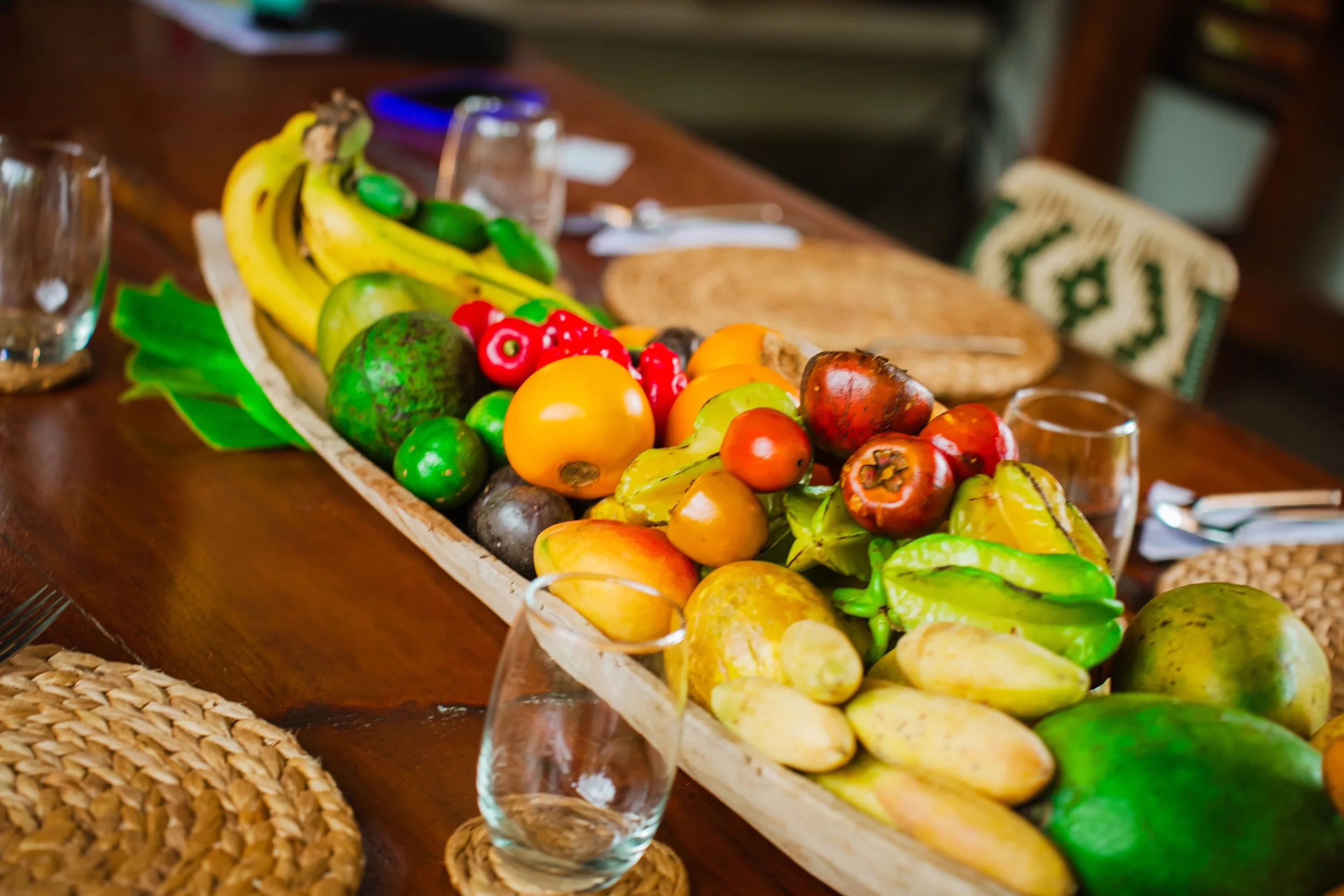 Tropical fruit in a wooden bowl on a table set for guests at Araucana Lodge.
