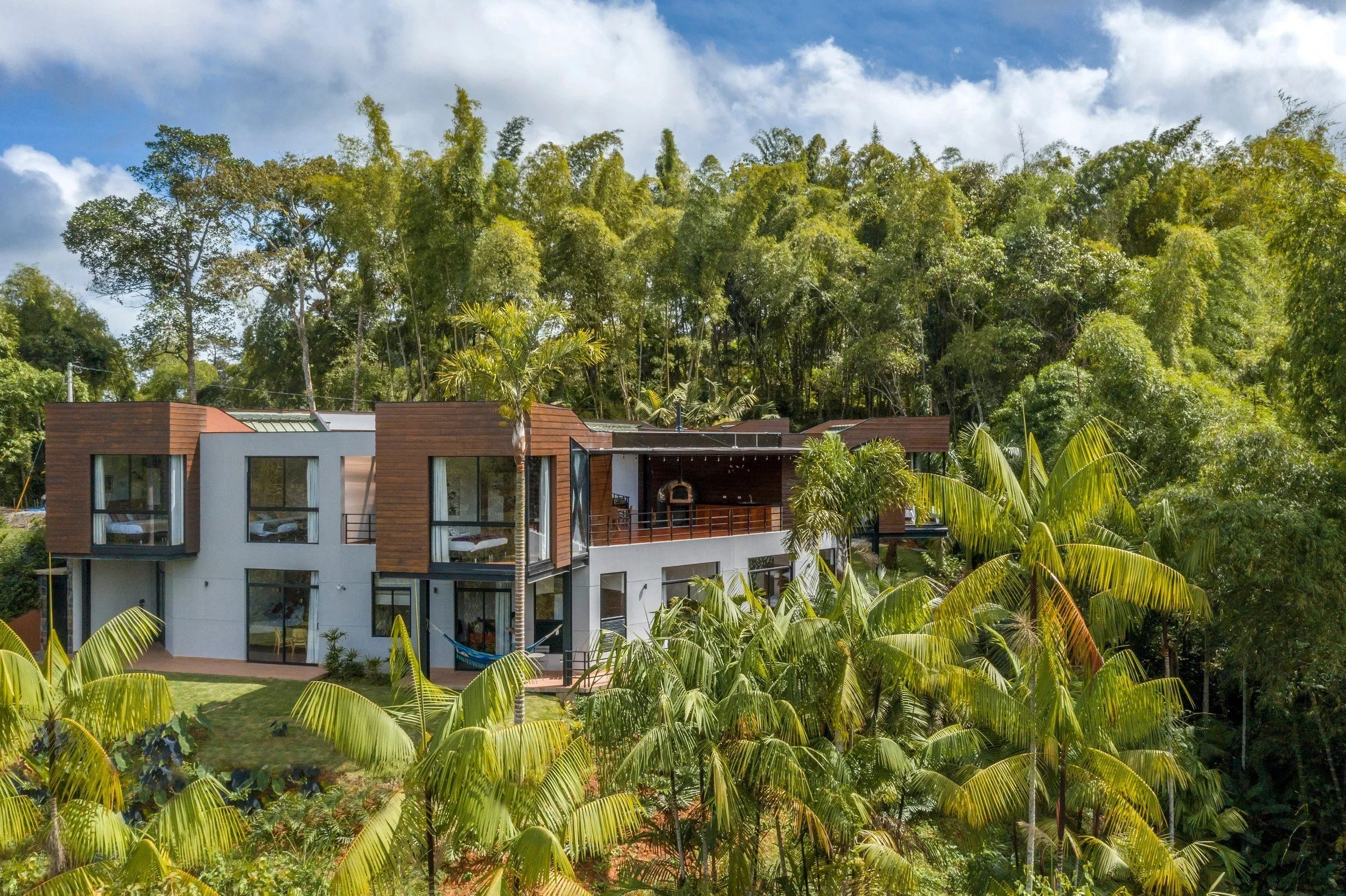Araucana Lodge’s guest rooms and covered terrace surrounded by palms and bamboo.