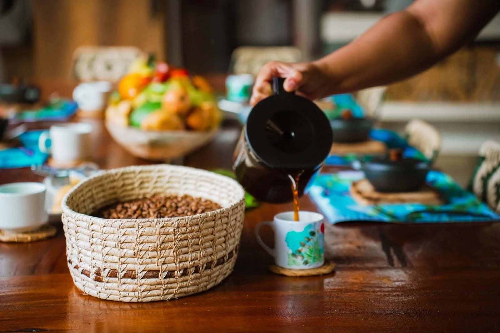 Coffee poured at Araucana Lodge’s dining table, beside a basket of coffee beans and fresh fruit.