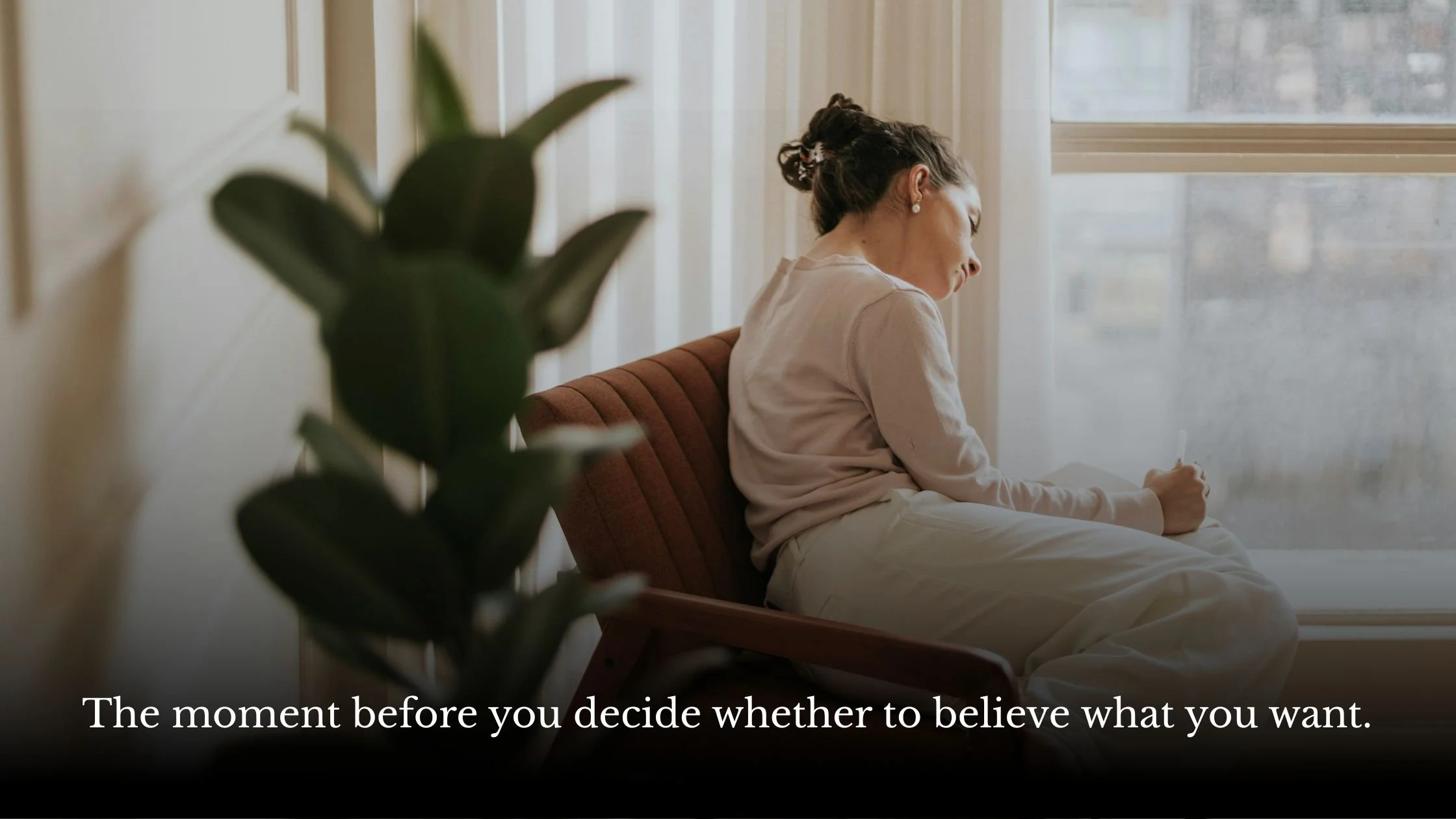 Woman journaling thoughtfully by a window, reflecting on a personal desire