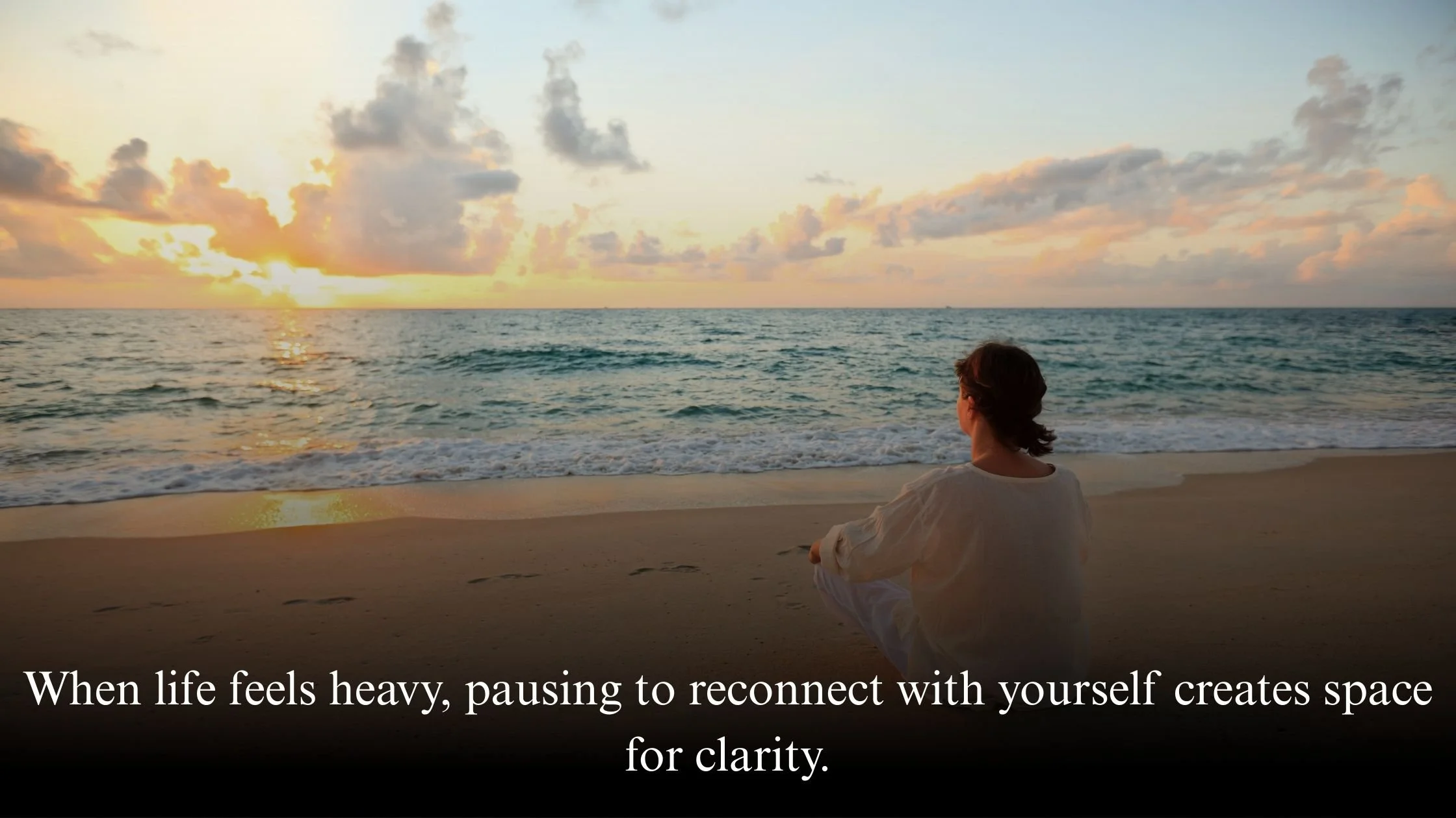 Woman reflecting by the sea, symbolising emotional clarity and self-awareness.