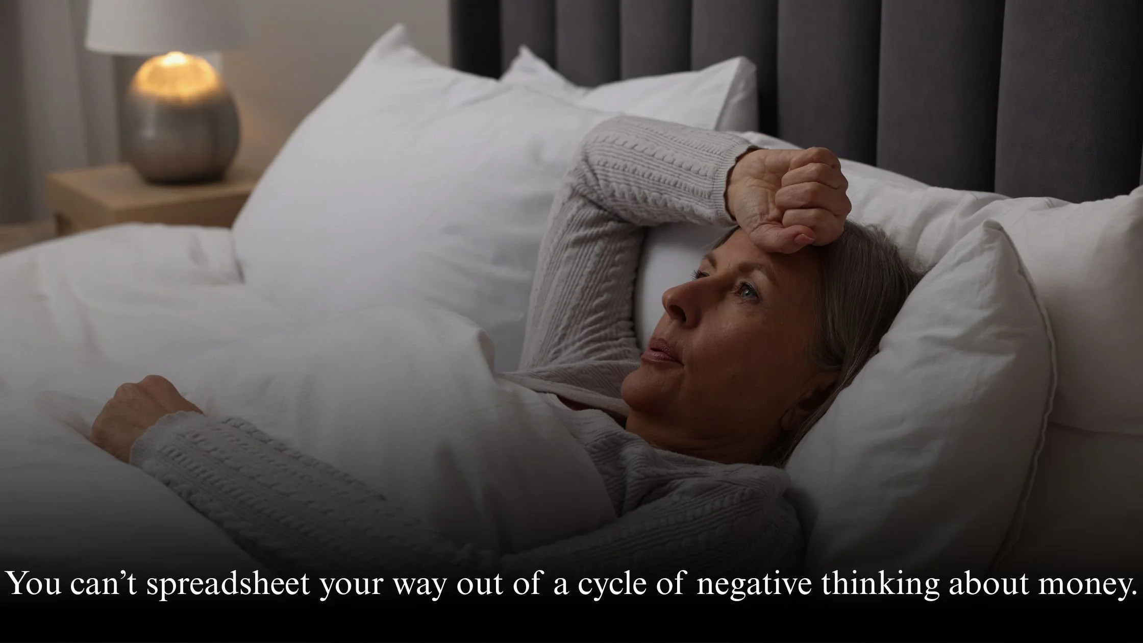 Midlife woman lying awake at night feeling worried about money