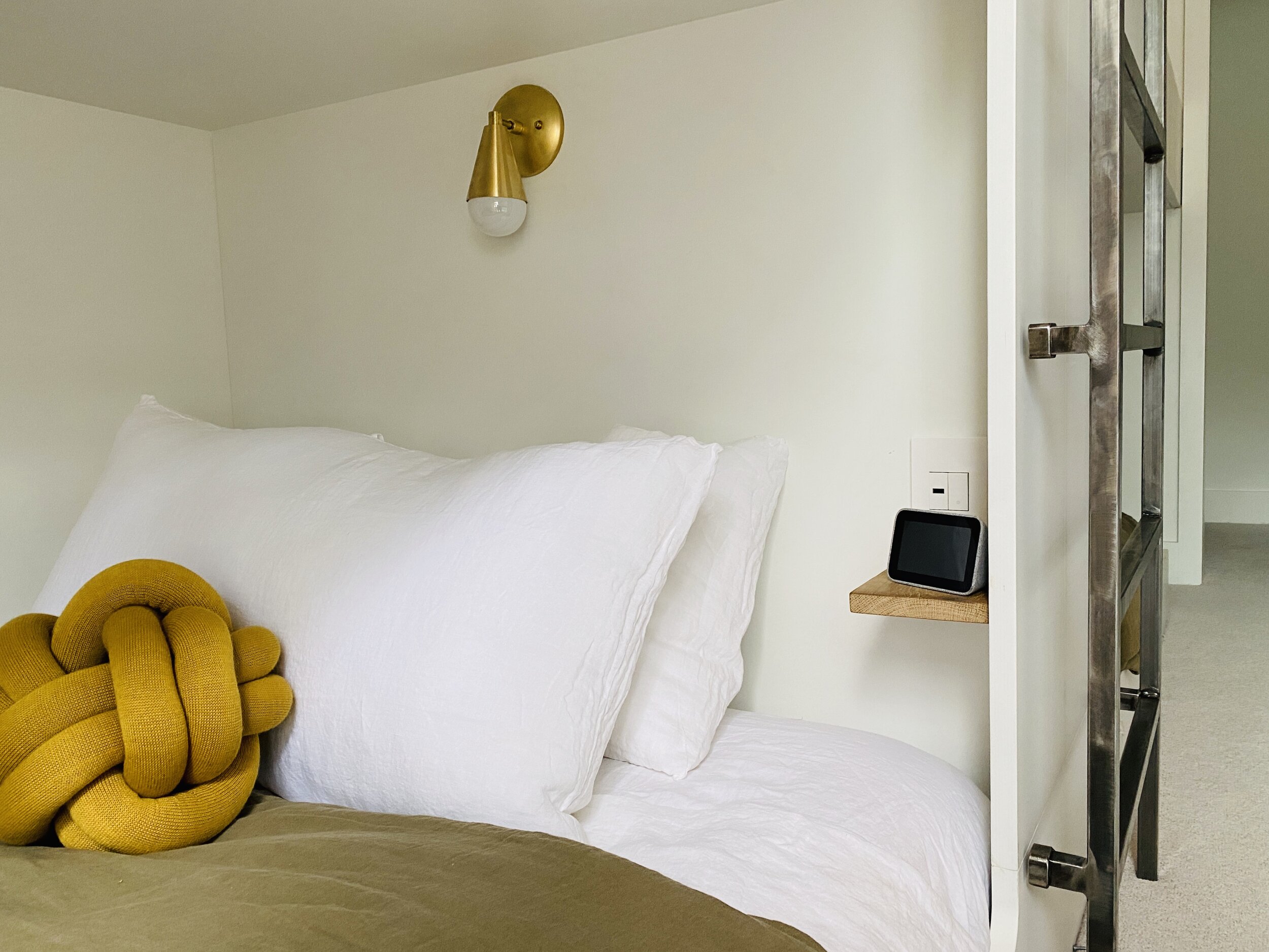 Bunkroom bottom bunk with pillows and light