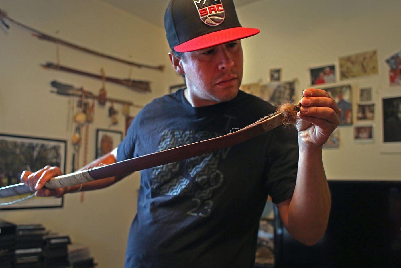  Hayfork, CA — Arron Sisk examines a bow pulled down from the the wall of Bob Burns. May 25, 2019. Tom Levy/The Spiritual Edge 