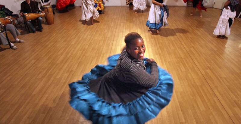  Afro-Cuban dance teacher Susana Arenas Pedroso demonstrates some moves for her students.  Photo Credit: Tom Levy 