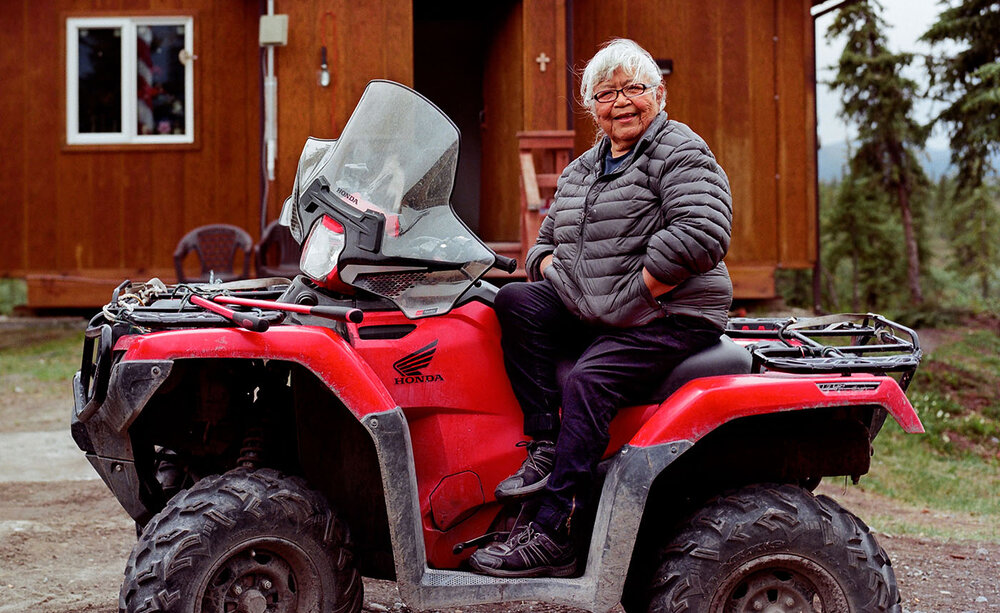 Gwich’in elder Sarah James in front of her old cabin in her hometown, Arctic Village, AK. 