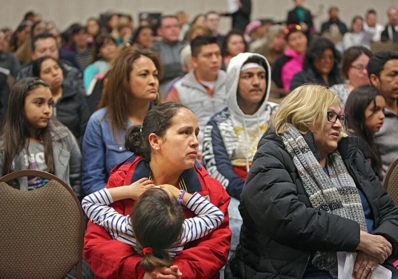  A mother and child sat with dozens of attendees in the St. Mary’s meeting room.   Photo Credit: Tom Levy. 