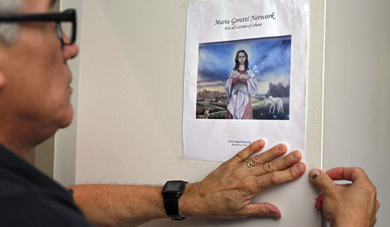  Miguel Prats sets out signs in preparation for a meeting of the Maria Goretti Network, a support group for victims of abuse.    Photo Credit: Annie Mulligan  