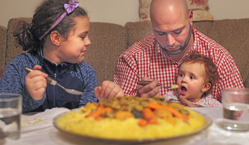  Otmane Benjilany eats couscous dinner with his two daughters in Cedar Rapids, Iowa on January 27, 2017. He immigrated from Morocco 11 years earlier. In 2017 he said he didn’t expect his life to change for the worse under President Trump.    Photo Cr