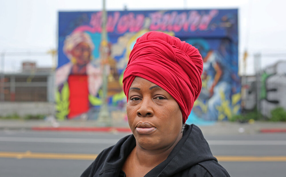 Regina Evans stands in front of a mural dedicated to her and sex trafficked youth. 