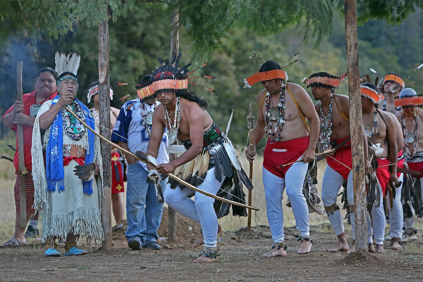  Lakehead, CA — Michael Preston enters the dance grounds with a traditional bow and arrow. He says his great-great-aunt Florence Jones taught him “the lesson of discipline and putting our heart into the dances and really praying during the dances.” S