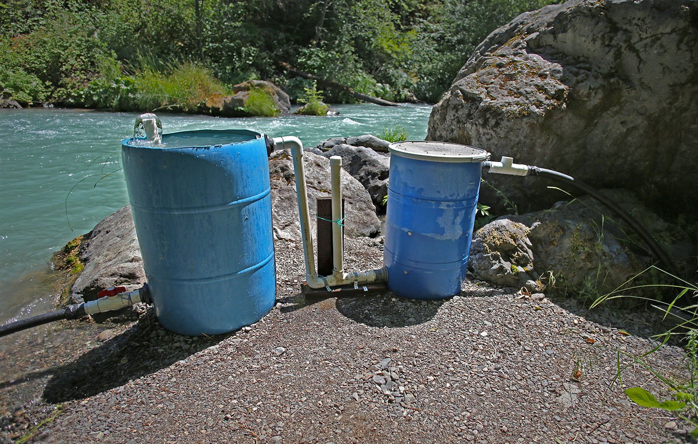  Shasta-Trinity National Forest — From about 200 feet away, a tube carries the river’s cold water runs into one of the blue barrels where the sediment can settle out. The clarified water then flows into the second barrel. Once the eggs hatch, the bab