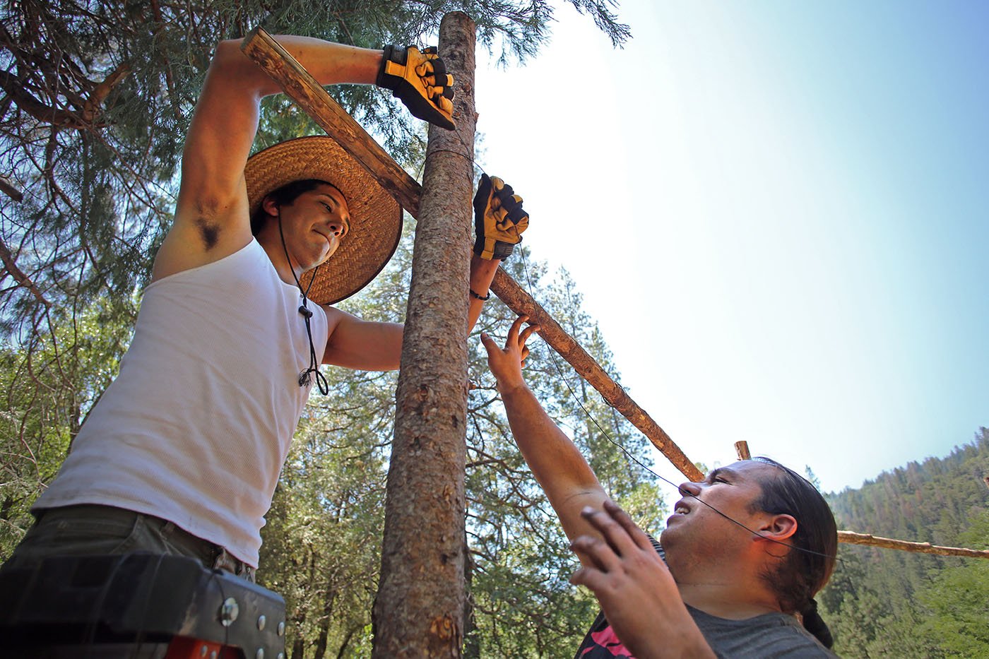  Shasta-Trinity National Forest — Construction of the ceremonial arbor requires digging holes into which the posts can be inserted and then tying posts across so that Douglas fir boughs can be laid on top. July 11, 2022. Tom Levy/The Spiritual Edge 