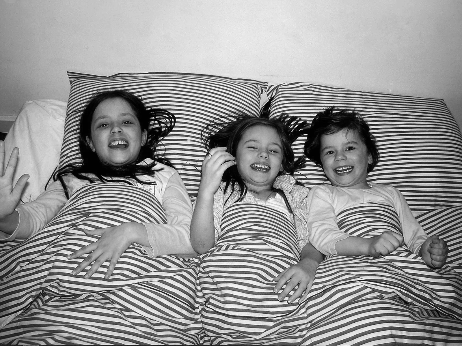 Meriel and her two sisters sharing a bed during childhood road trips across Europe.